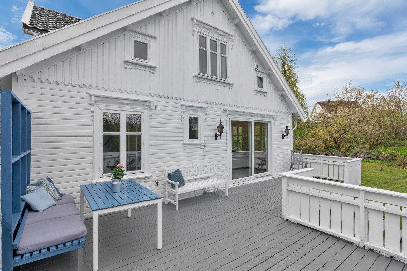 Solrik tomt med lune uteplasser, grønne plenområder og frodig beplantning Galleribilde