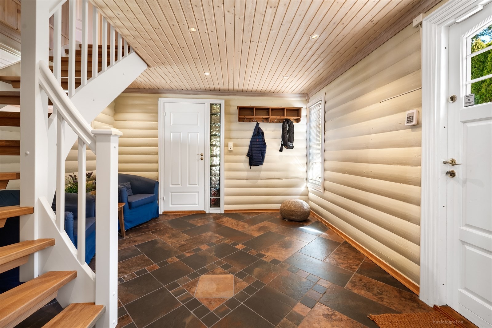 Romslig entré med plass til oppbevaring. Den malte tretrappen har lakkerte trinn. Galleribilde