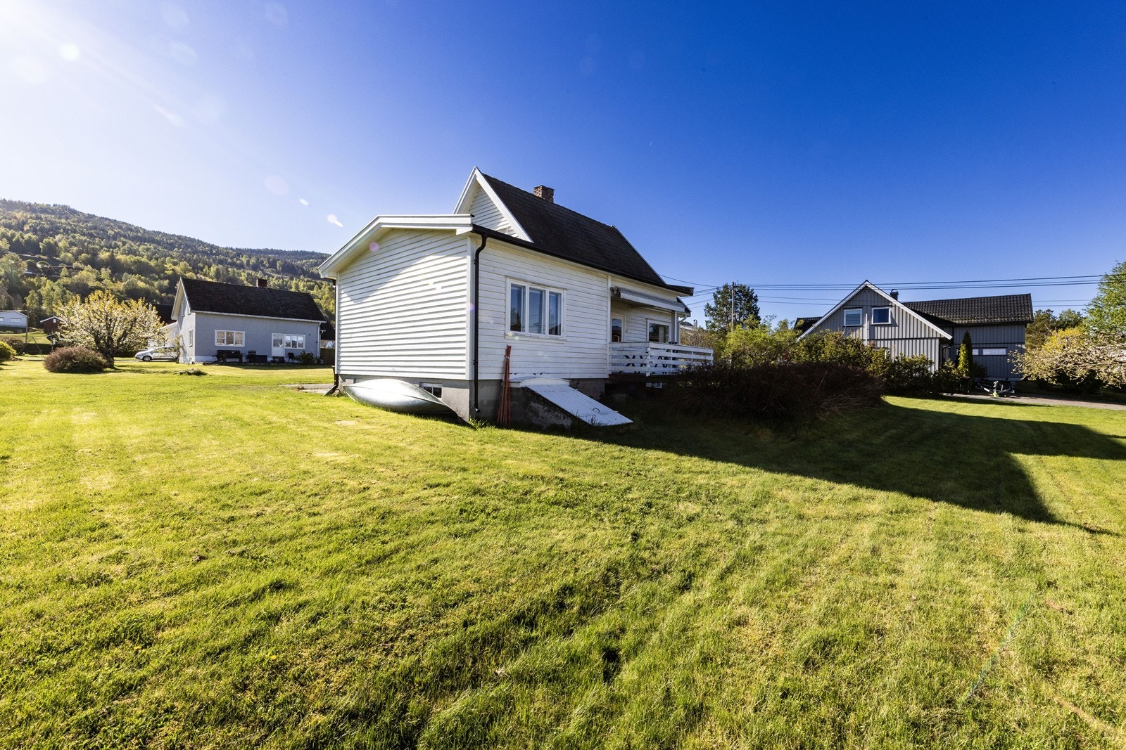 Eiendommen ligger i et relativt flatt terreng med stor hage. Galleribilde