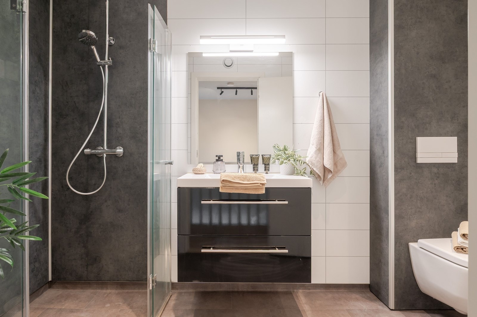 Pent og moderne bad med belegg på gulvet og baderomsplater på veggene. I gulvet er det varmekabler. Galleribilde