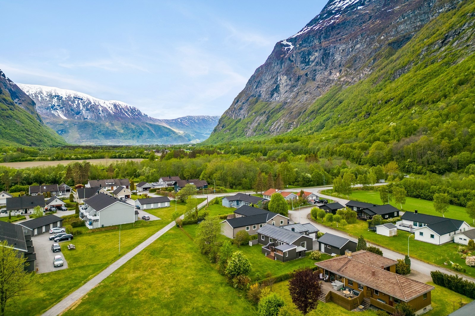 Huset har en veranda med terrassebord og rekkverk av treverk. Galleribilde