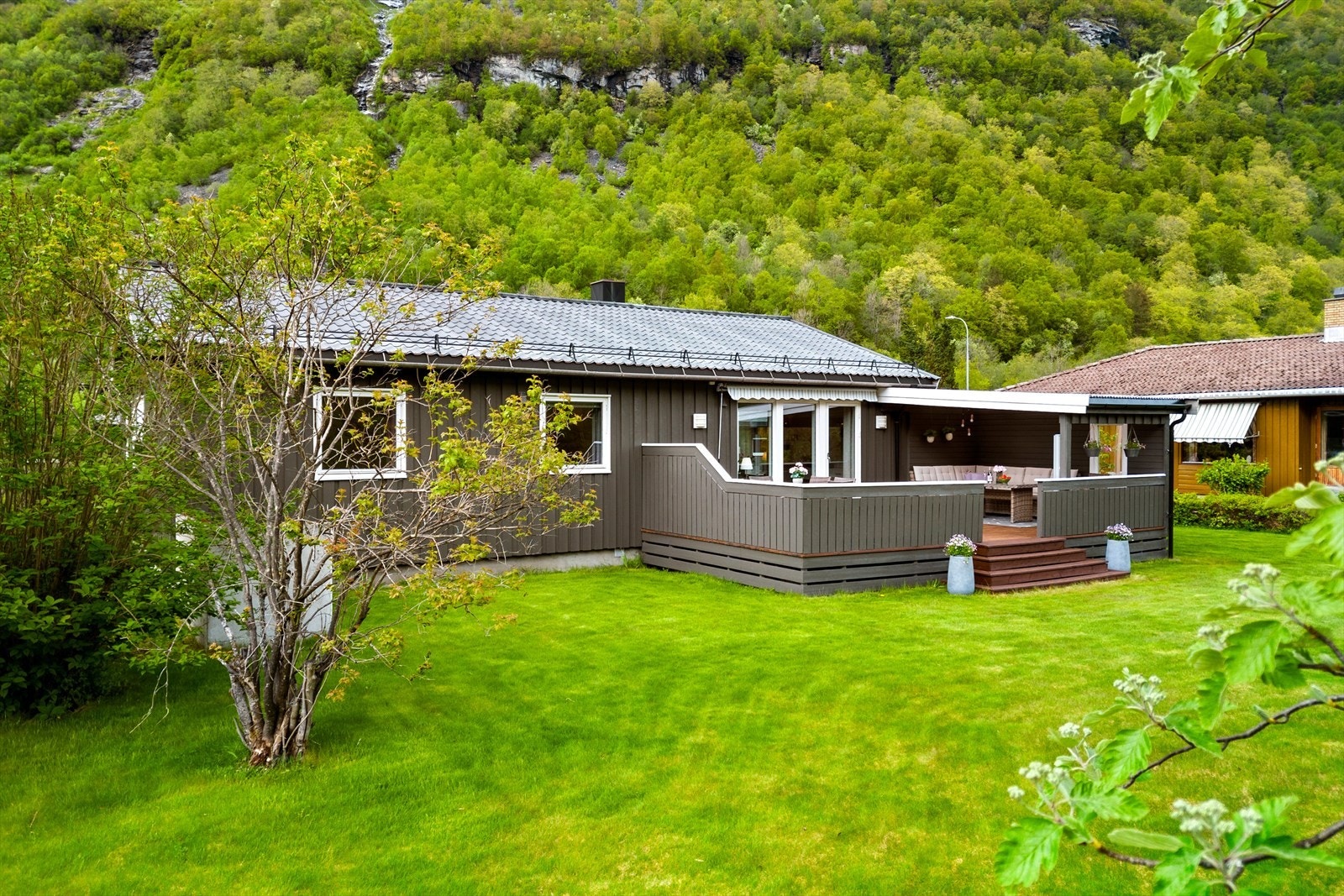 Det er en veranda med terrasseløsning som gir ekstra uteplass. Galleribilde