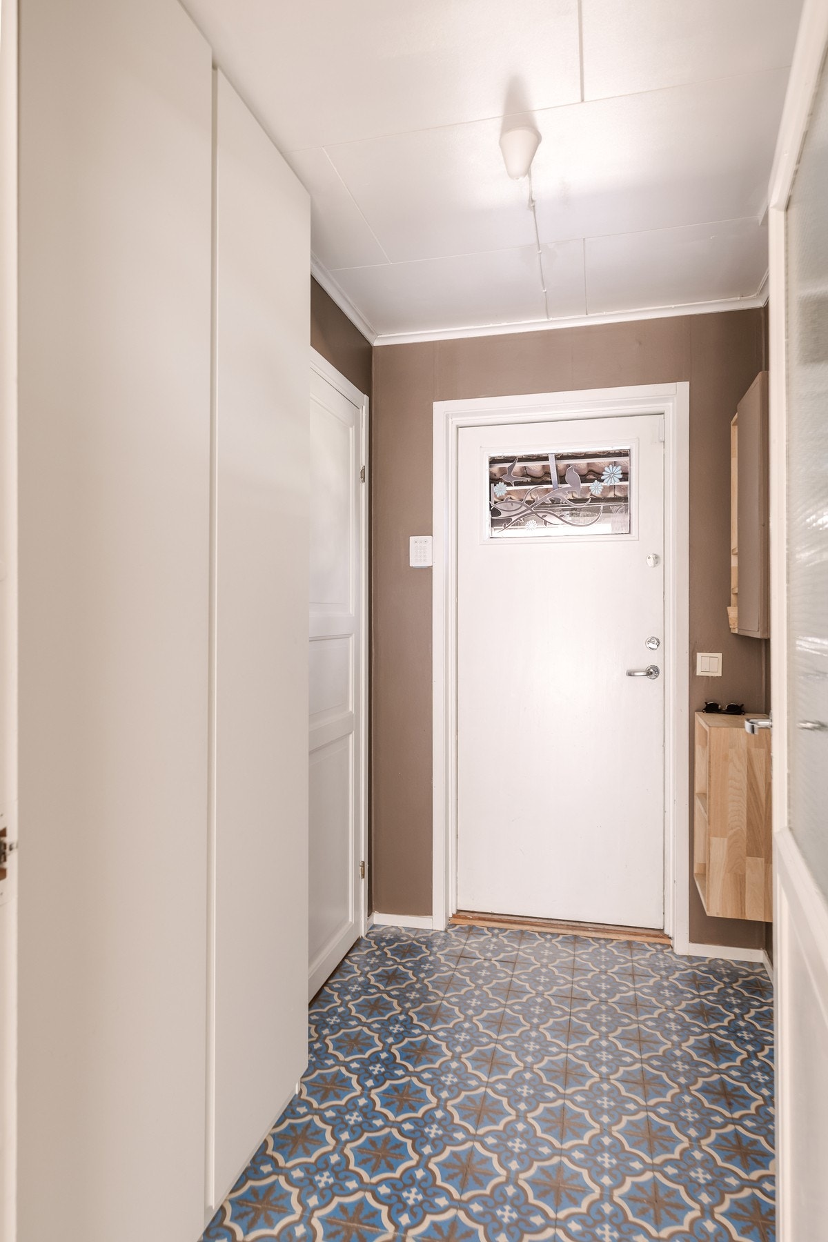 Boligen ønsker deg velkommen inn i en praktisk entré med flislagte gulv som tåler både våte sko, yttertøy og aktive hverdager. Galleribilde