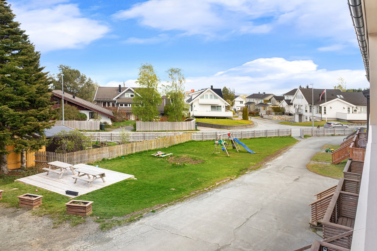 Utsikt mot grønne fellesarealer fra svalgangen. Galleribilde