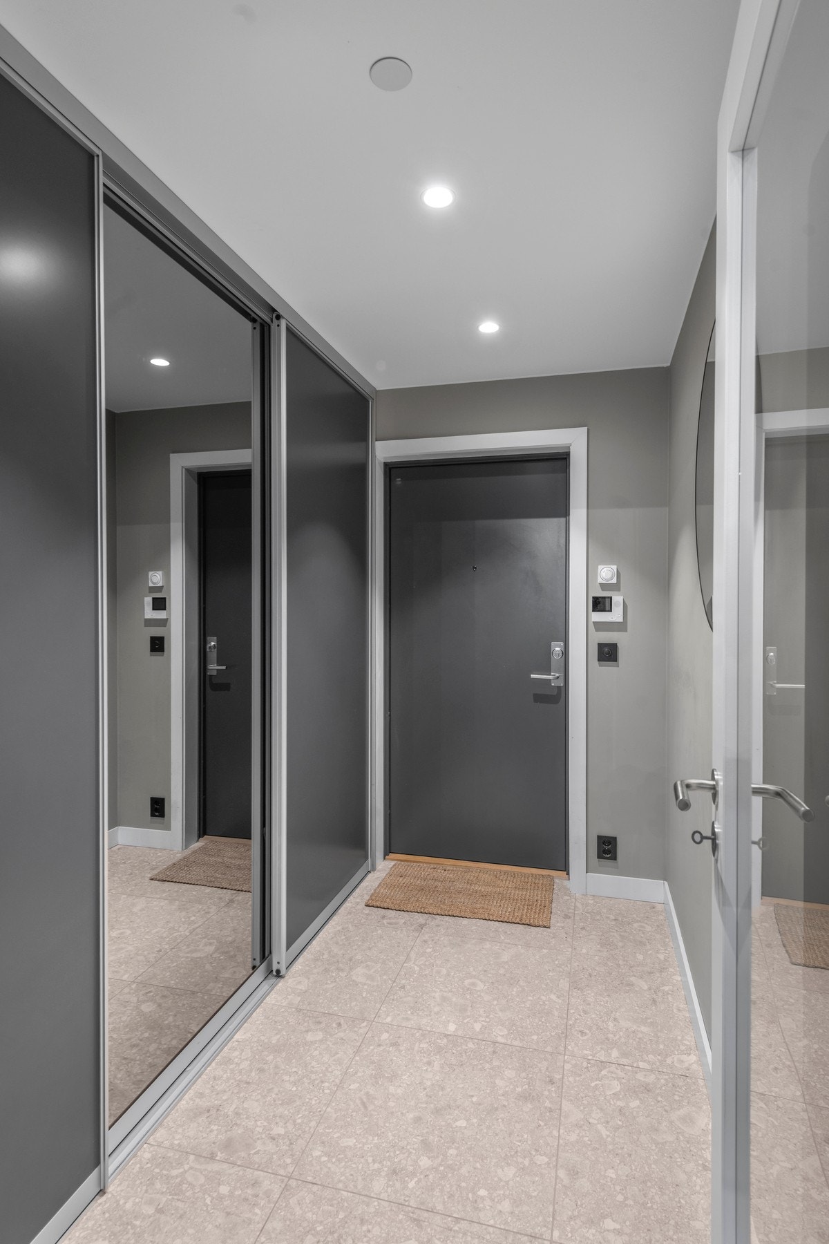 Velkommen inn til en lys og trivelig entré med skyvedørsgarderobe med speil Galleribilde