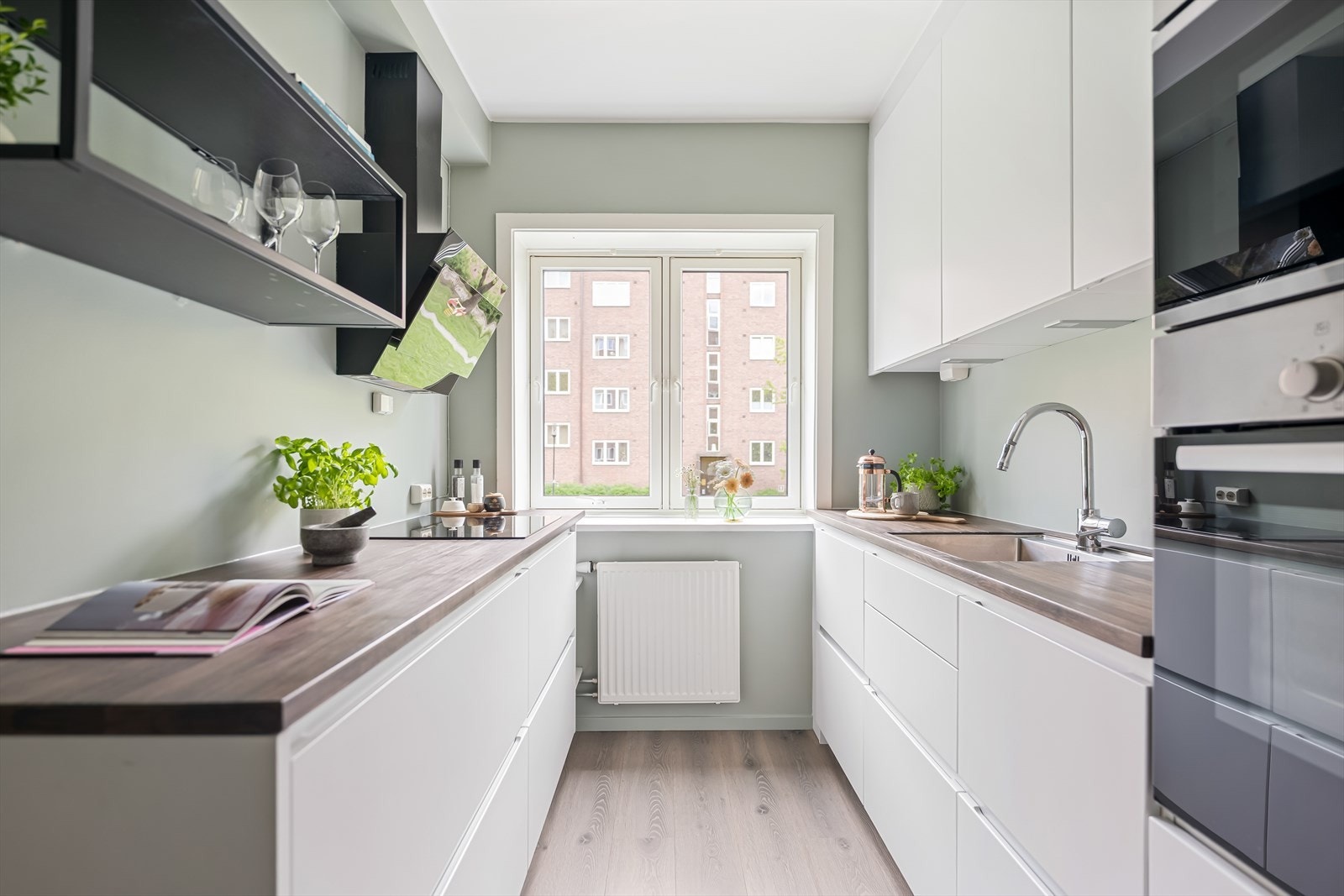 Kvalitetskjøkken fra Kvik, innredning med glatte fronter, benkeplate i heltre med underlimt kum i rustfritt stål og ledlys under overskap. Galleribilde