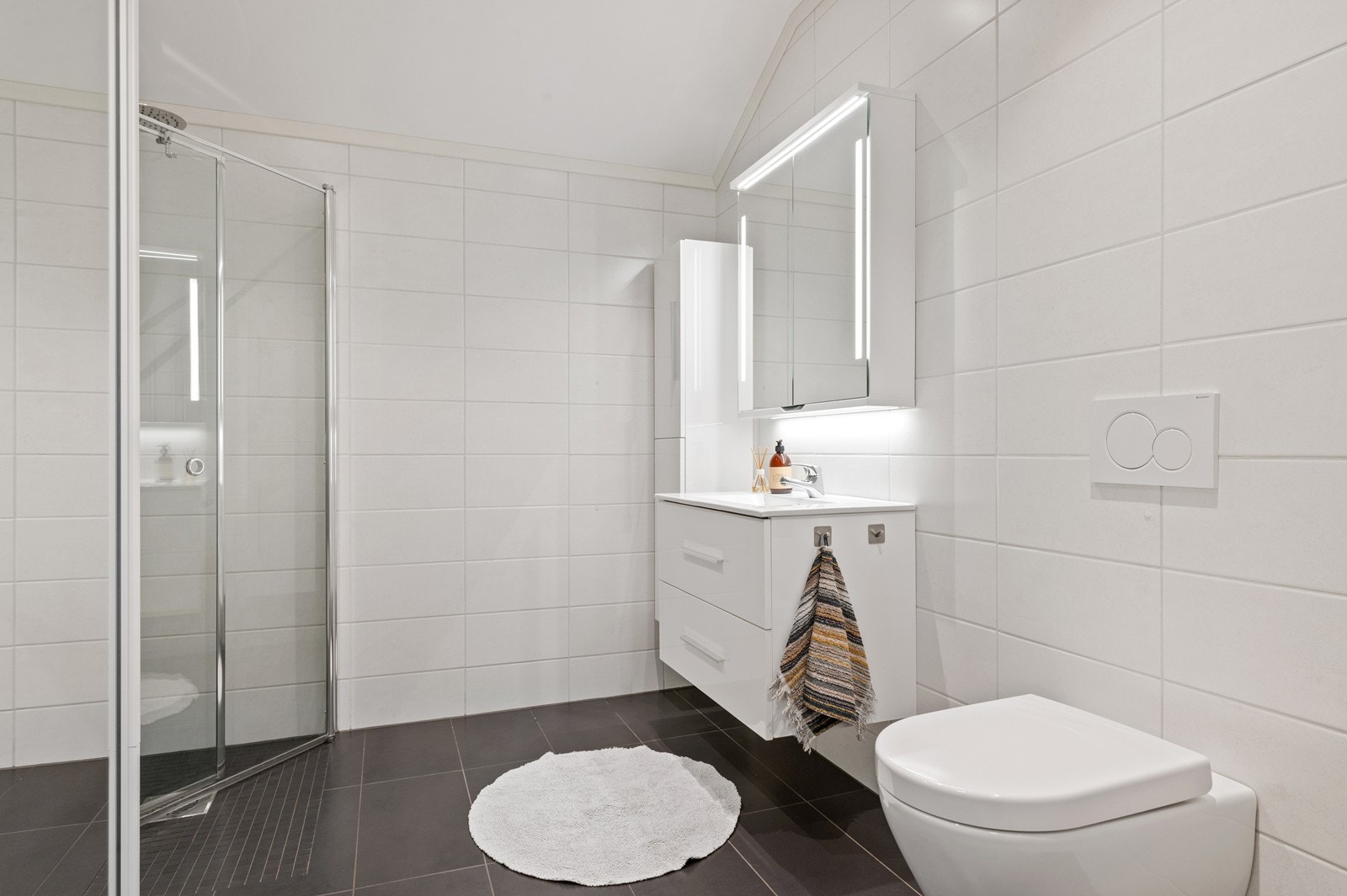 Badet er innredet med vegghengt toalett, servantinnredning og har opplegg for vaskemaskin. Galleribilde