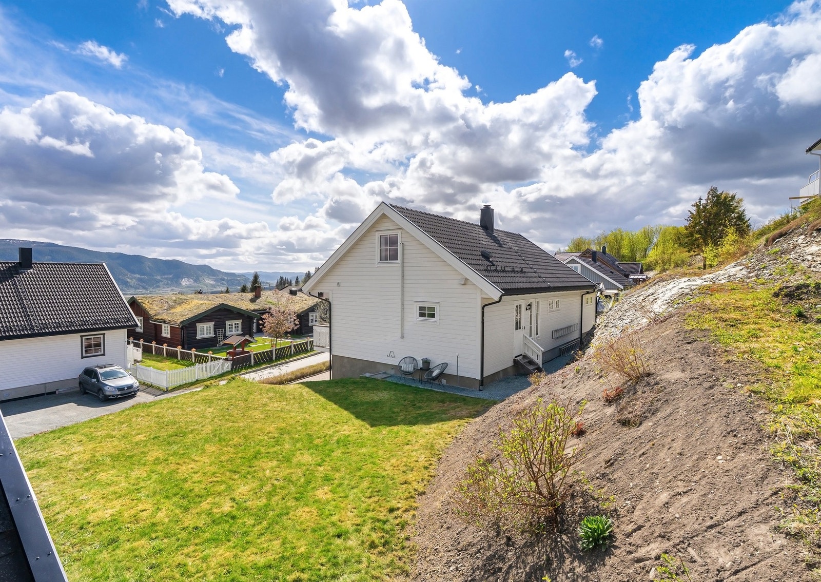 Hyggelig uteområde med plen og plass til sittegruppe langs fasaden. Galleribilde