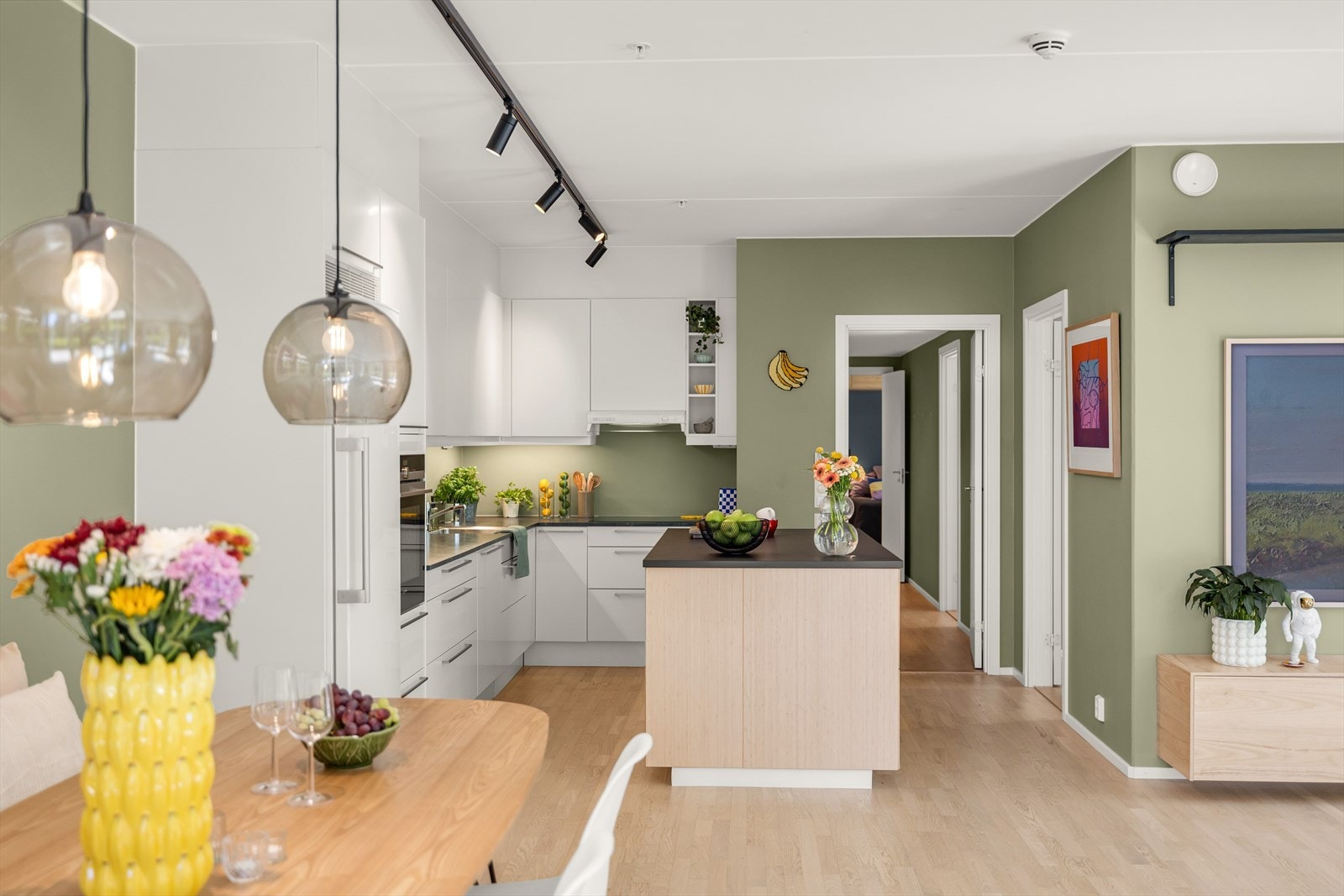 I åpen løsning fra stuen har leiligheten et flott, delikat kjøkken fra Sigdal med kjøkkenøy som gir en fin separasjon fra stuen. Kjøkkenøyen ble satt inn i 2022. Galleribilde