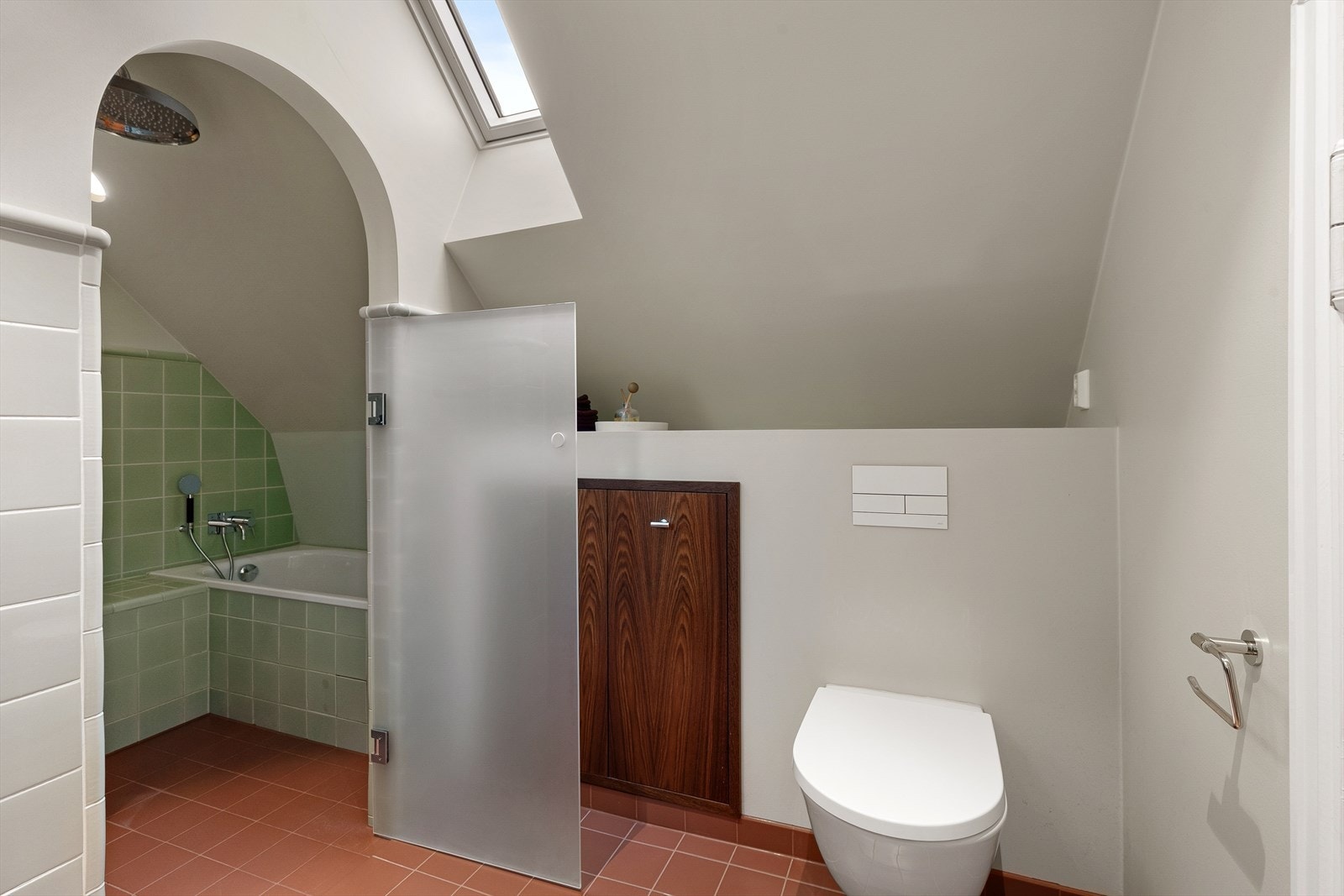 Badet er utstyrt med heldekkende servant med underskap, speil på vegg, toalett og dusjnisje med regndusj og innmurt badekar Galleribilde