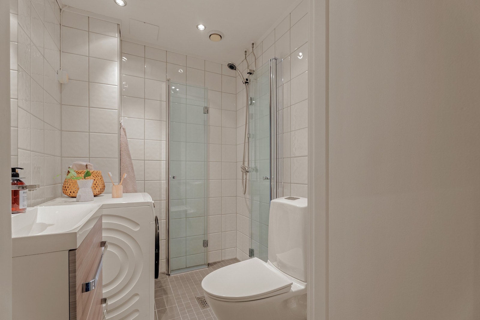 Fra entreen finner vi inngangen til badet. Det er innredet med dusjhjørne, servantskap og toalett. Galleribilde