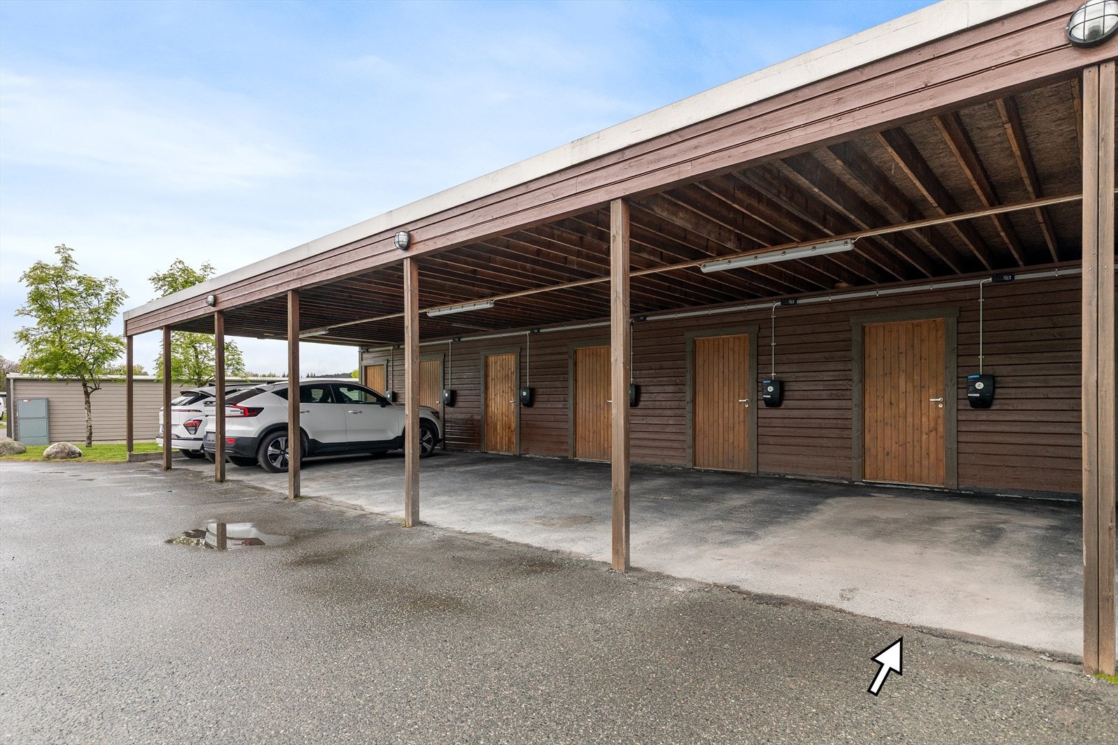 Det medfølger en carport med elbillader og sportsbod Galleribilde