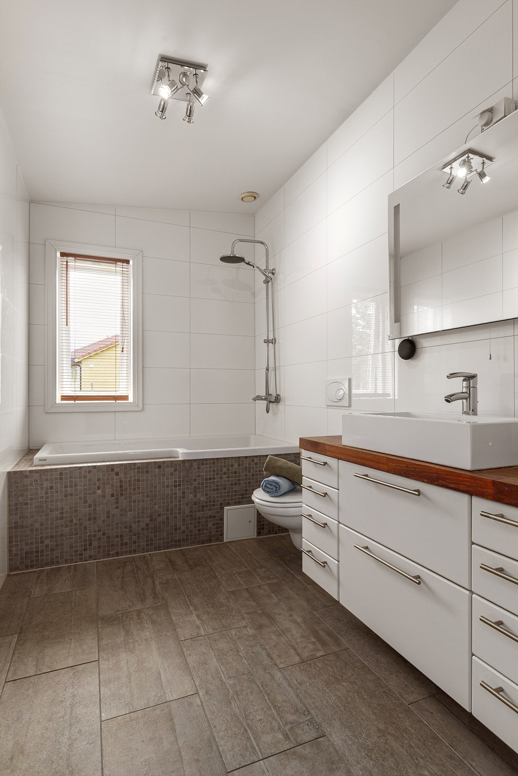 Badet har romslig innredning med gode oppbevaringsmuligheter Galleribilde