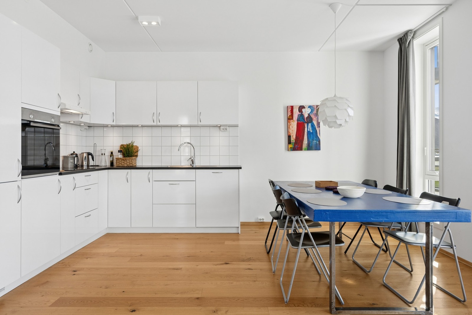 Kjøkkeninnredning med slette, hvite fronter og laminatbenkeplate. Galleribilde