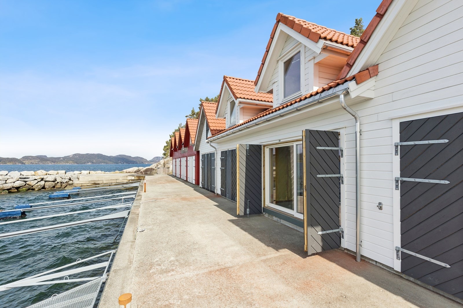 Naustet ligger i en etablert rekke fra 2018, med kaiplass rett utenfor. Eiendommen selges som et uinnredet prosjekt. Galleribilde