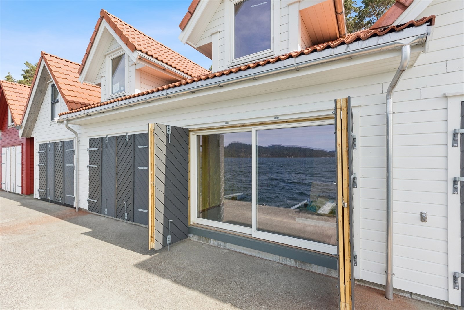 Fasaden har liggende trekledning og taket er tekket med takstein av betong. Galleribilde