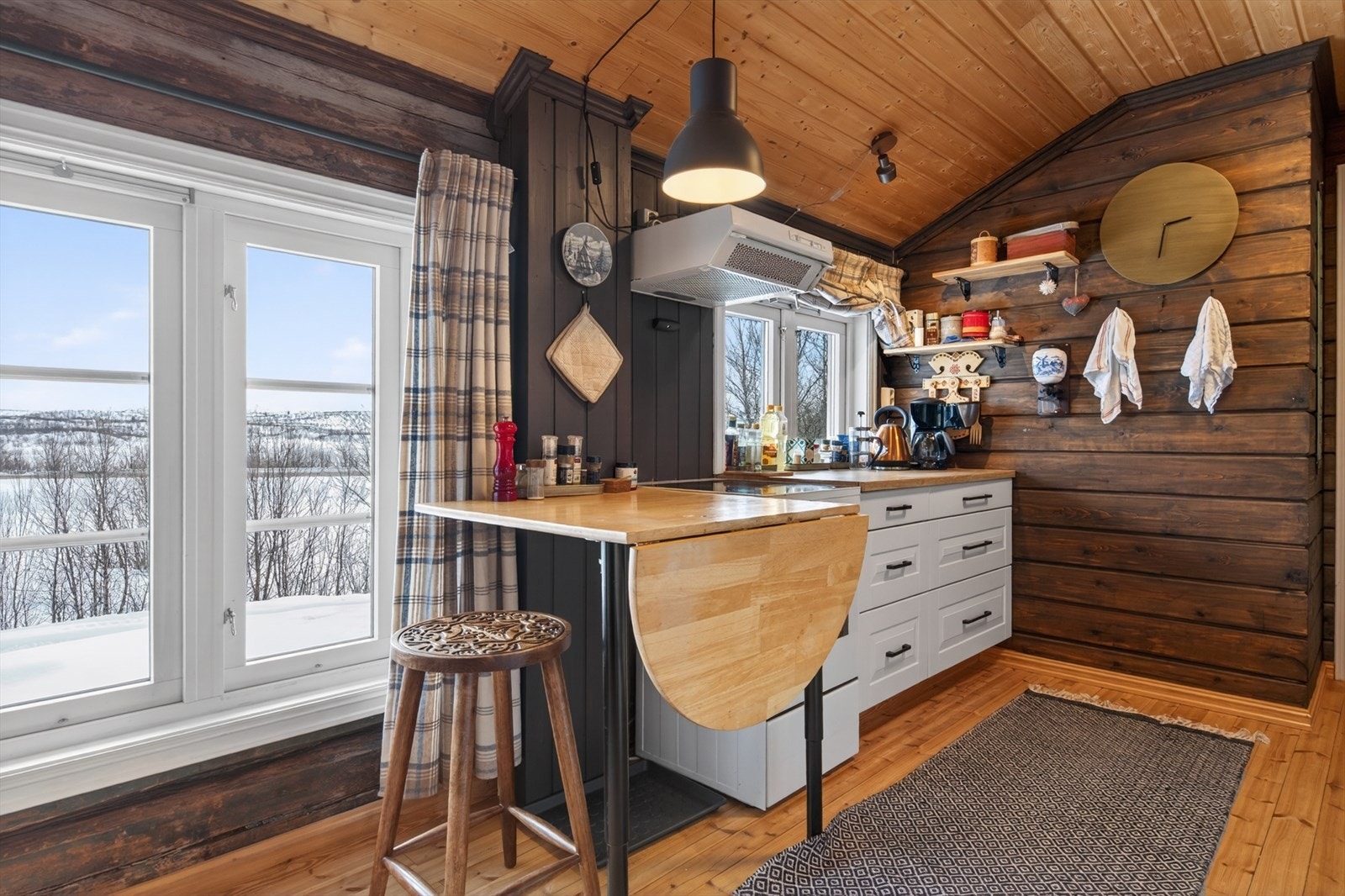 Kjøkken med sjarmerende treverk og praktisk spiseplass. Stort vindu med nydelig utsikt mot landskapet utenfor. Galleribilde