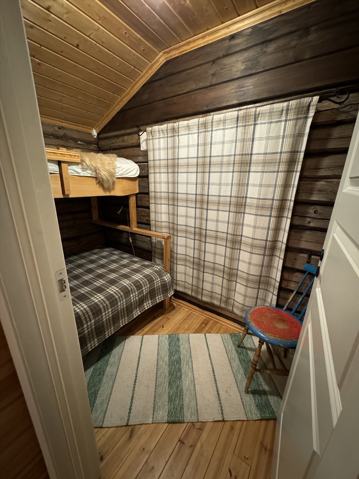 Koselig soverom 2 med tømmervegger og skråtak, perfekt for en hytteopplevelse. Sjarmerende detaljer gir en lun atmosfære - Selgers foto Galleribilde