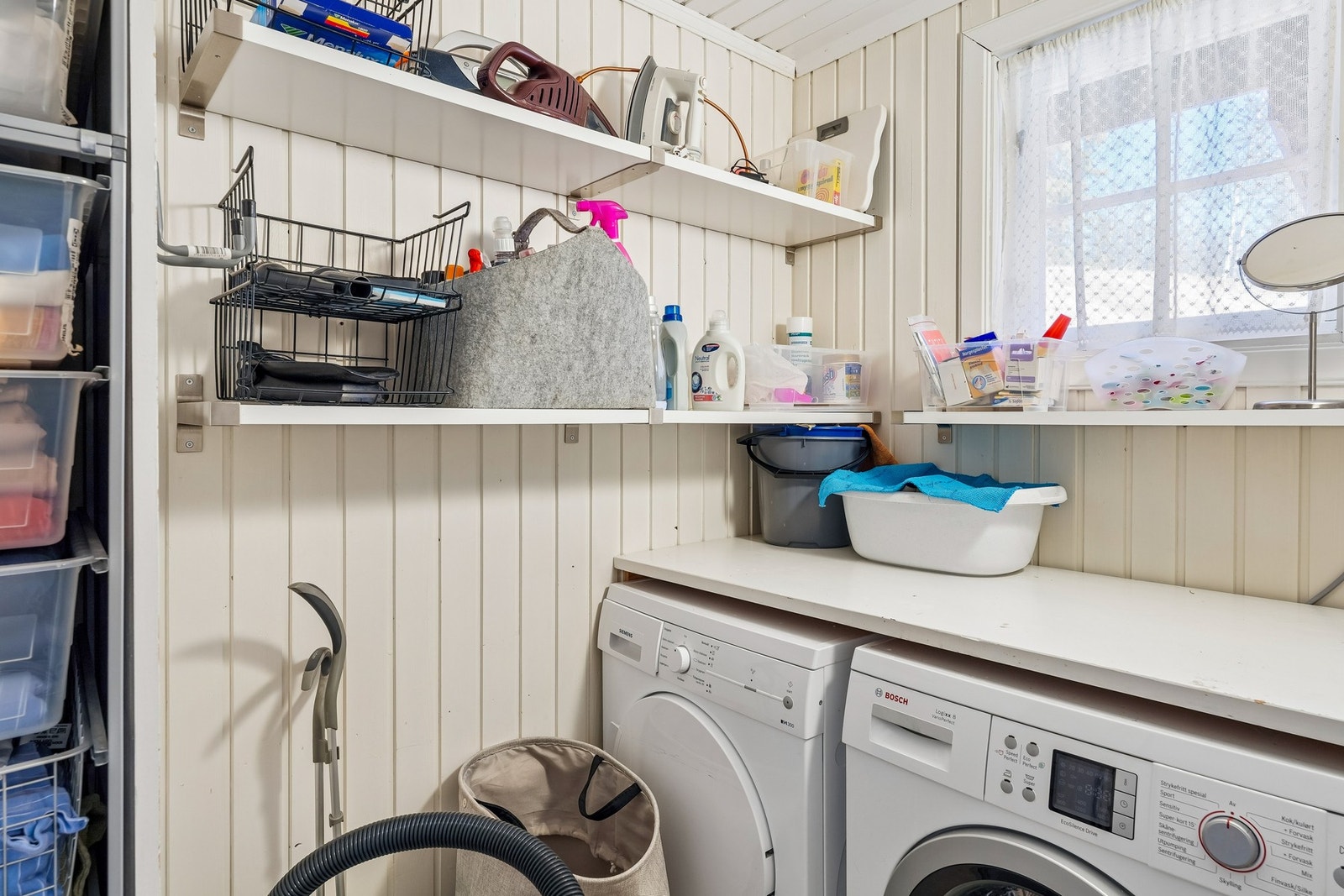 Eget vaskerom med plass til vaskemaskin og tørketrommel, og med plassbygde skap og hyller til oppbevaring. Galleribilde