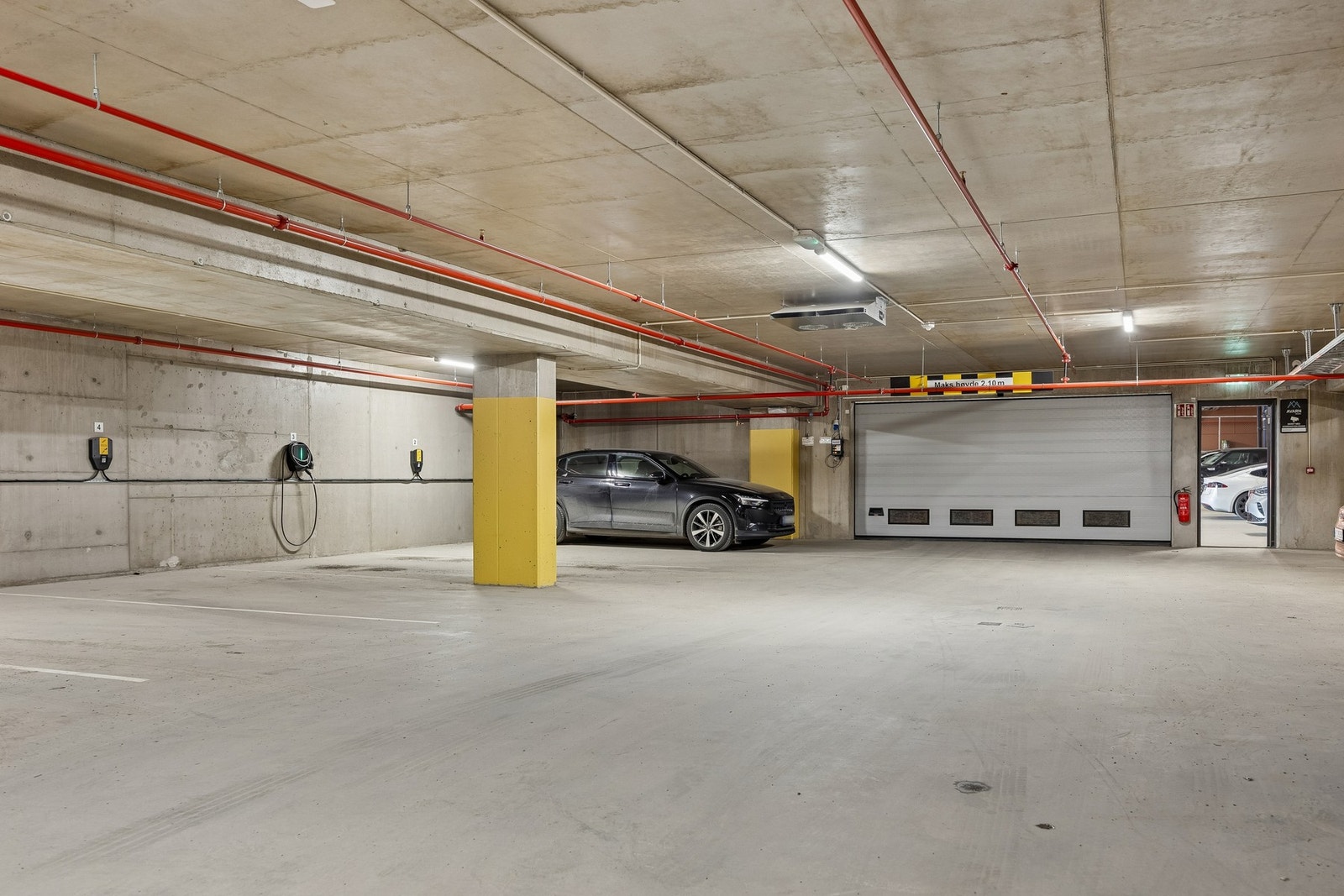 Parkeringsplass med elbil lader i kjeller følger handelen. Galleribilde