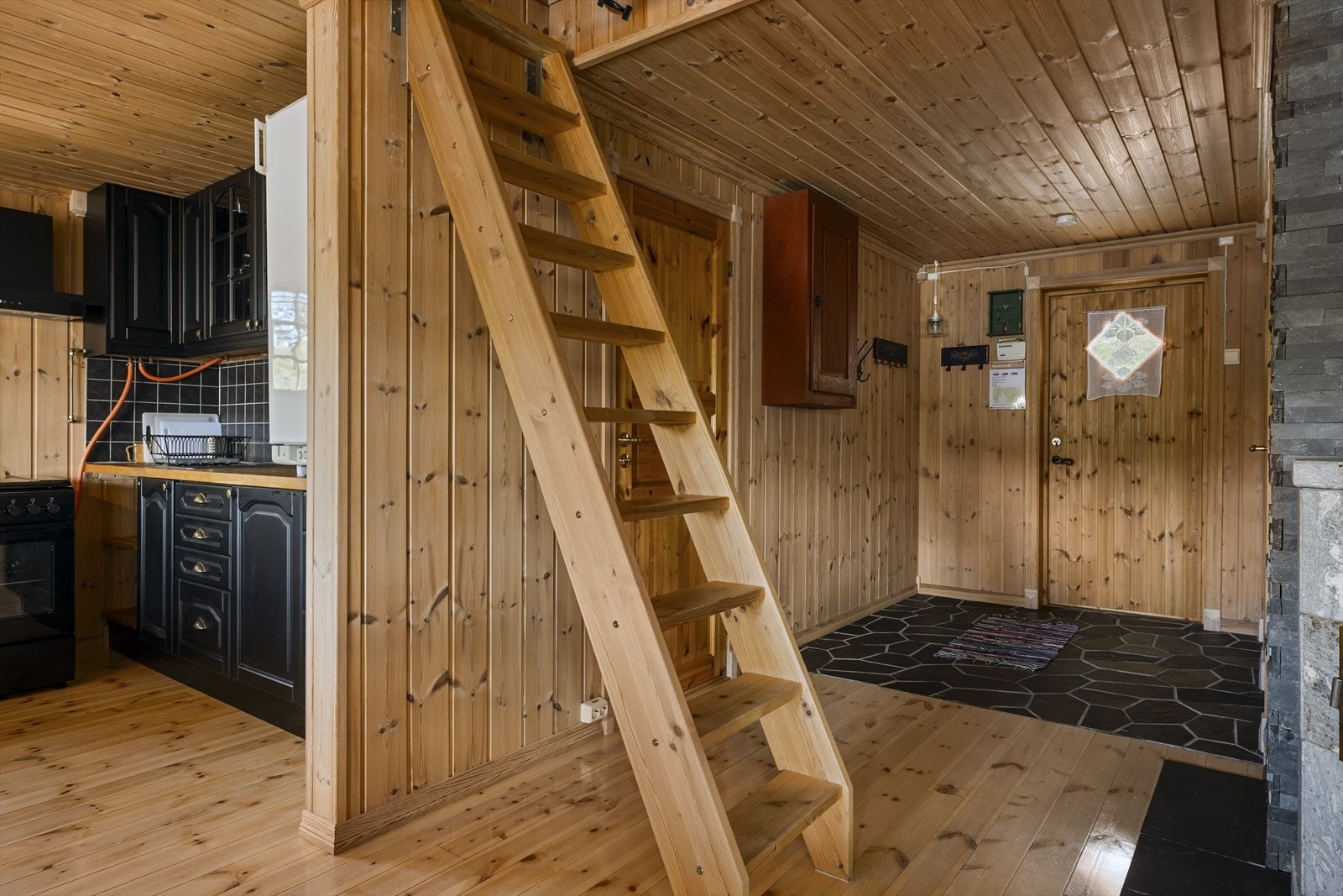 Innvendig har hytta panel, heltre gulv samt skiferfliser i entreen. Galleribilde