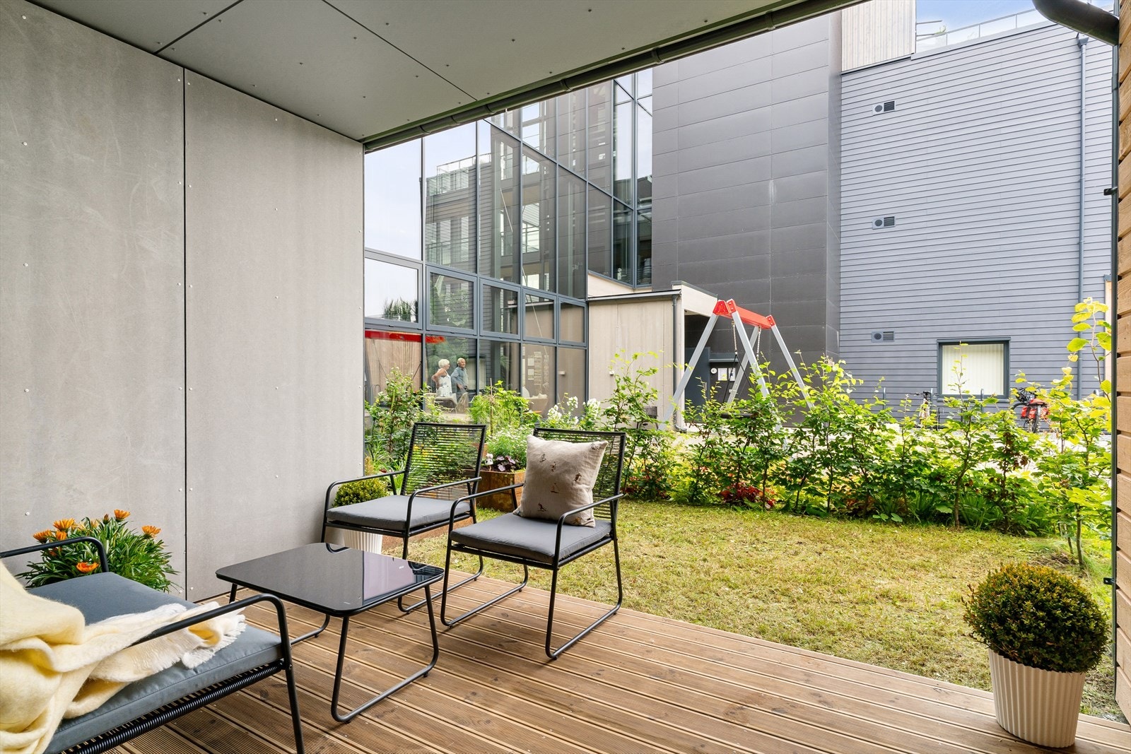 Balkongen i front av boligen har også en koselig liten hageflekk med hekkebeplantning. Galleribilde
