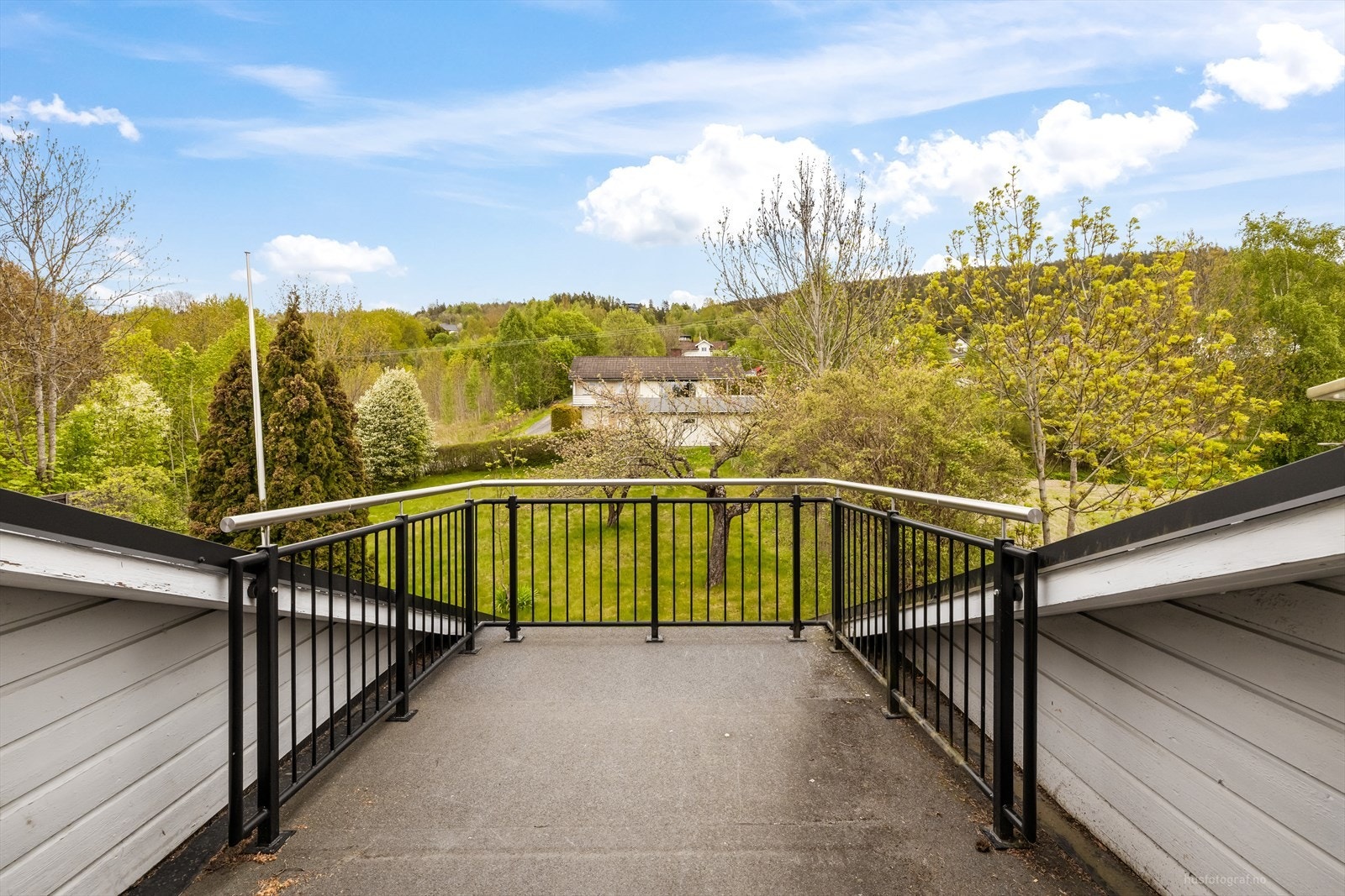 Terrasse i andre etasje med rekkverk i metall. Herfra er det utsikt over nærområdet. Galleribilde