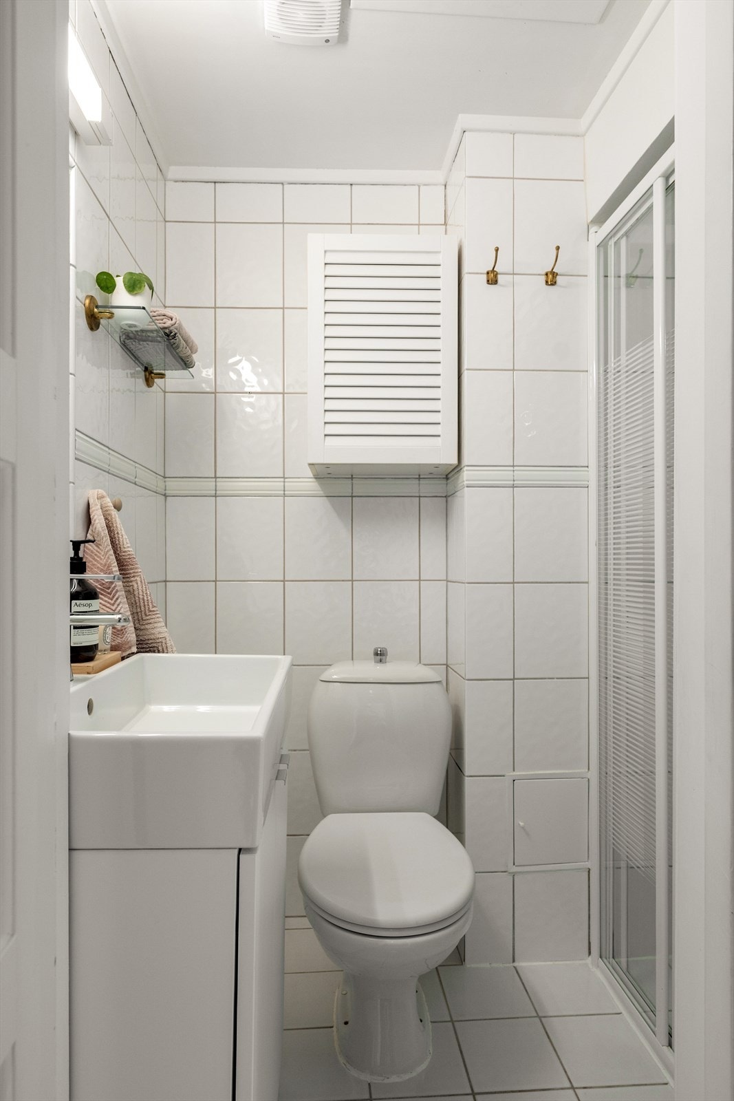 Tidløst flislagt bad med gulvvarme. Innredning bestående av dusjnisje, servantskap og wc. Galleribilde