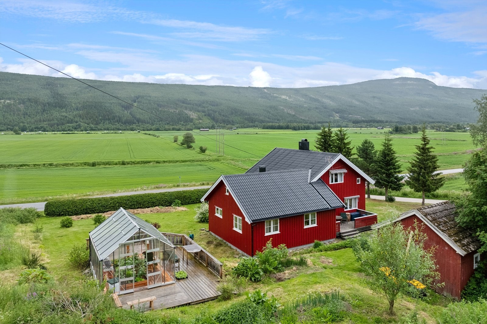 På eiendommen står det også et drivhus med fin terrasseplatting. Galleribilde