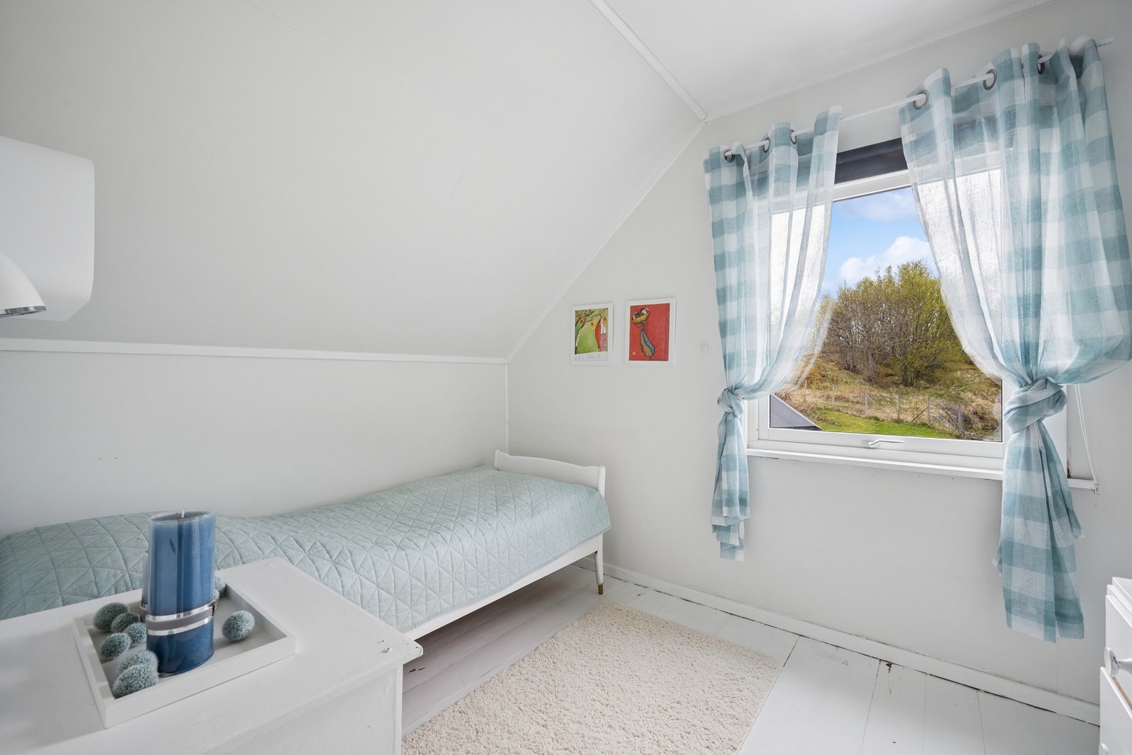 Et lyst soverom med vindu mot hagen. Galleribilde