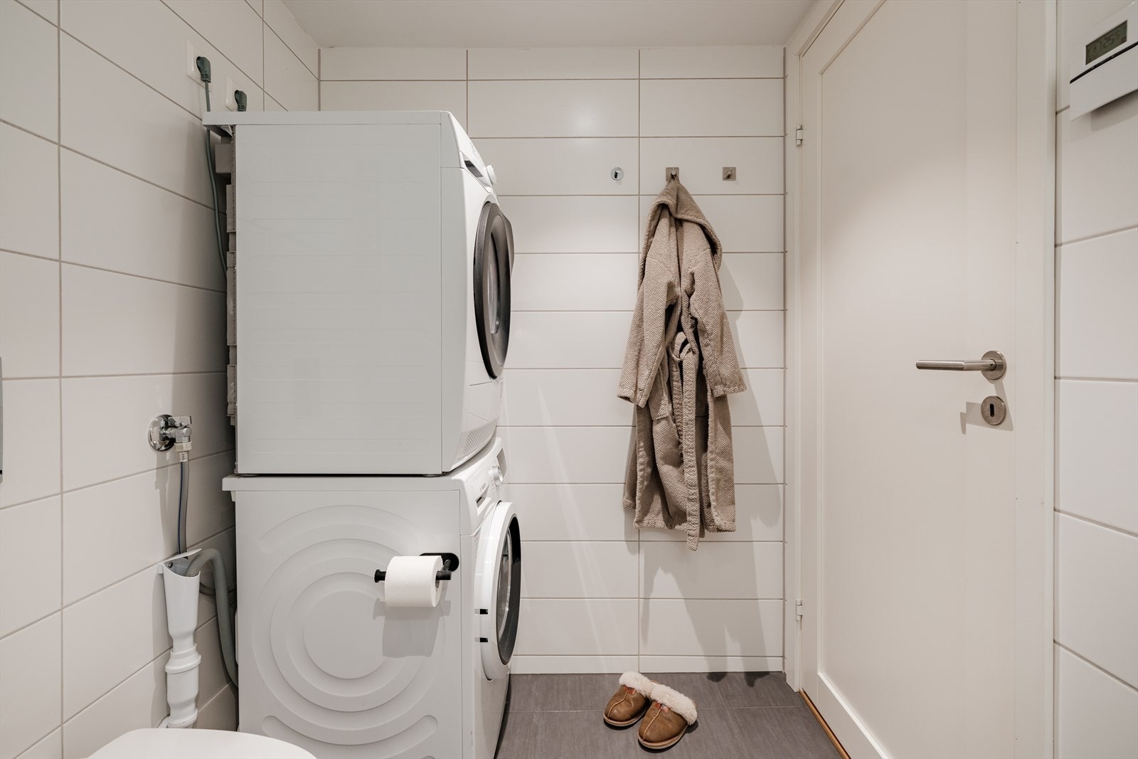 Badet har vegghengt toalett og opplegg for vaskemaskin. Galleribilde