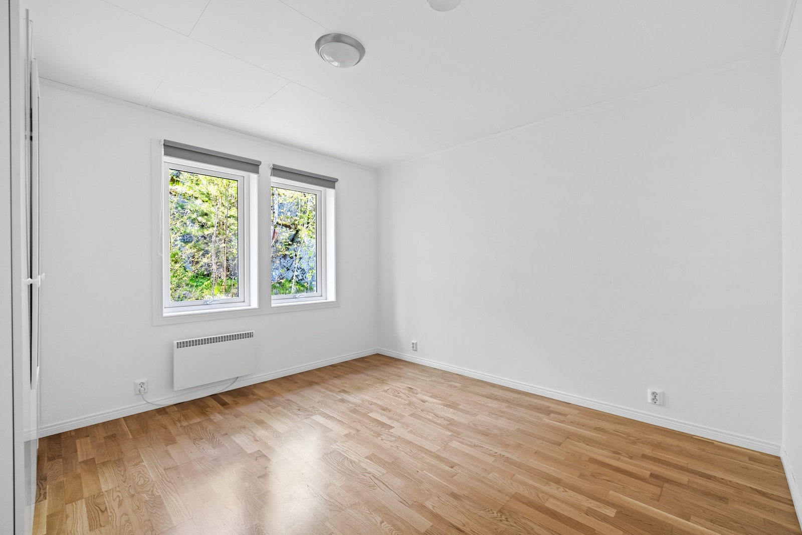 Her har du god plass til en stor dobbeltseng med tilhørende møblement og gode lysforhold. Rommet har hvitmalte vegger og tre-stavs parkett på gulvene. Galleribilde