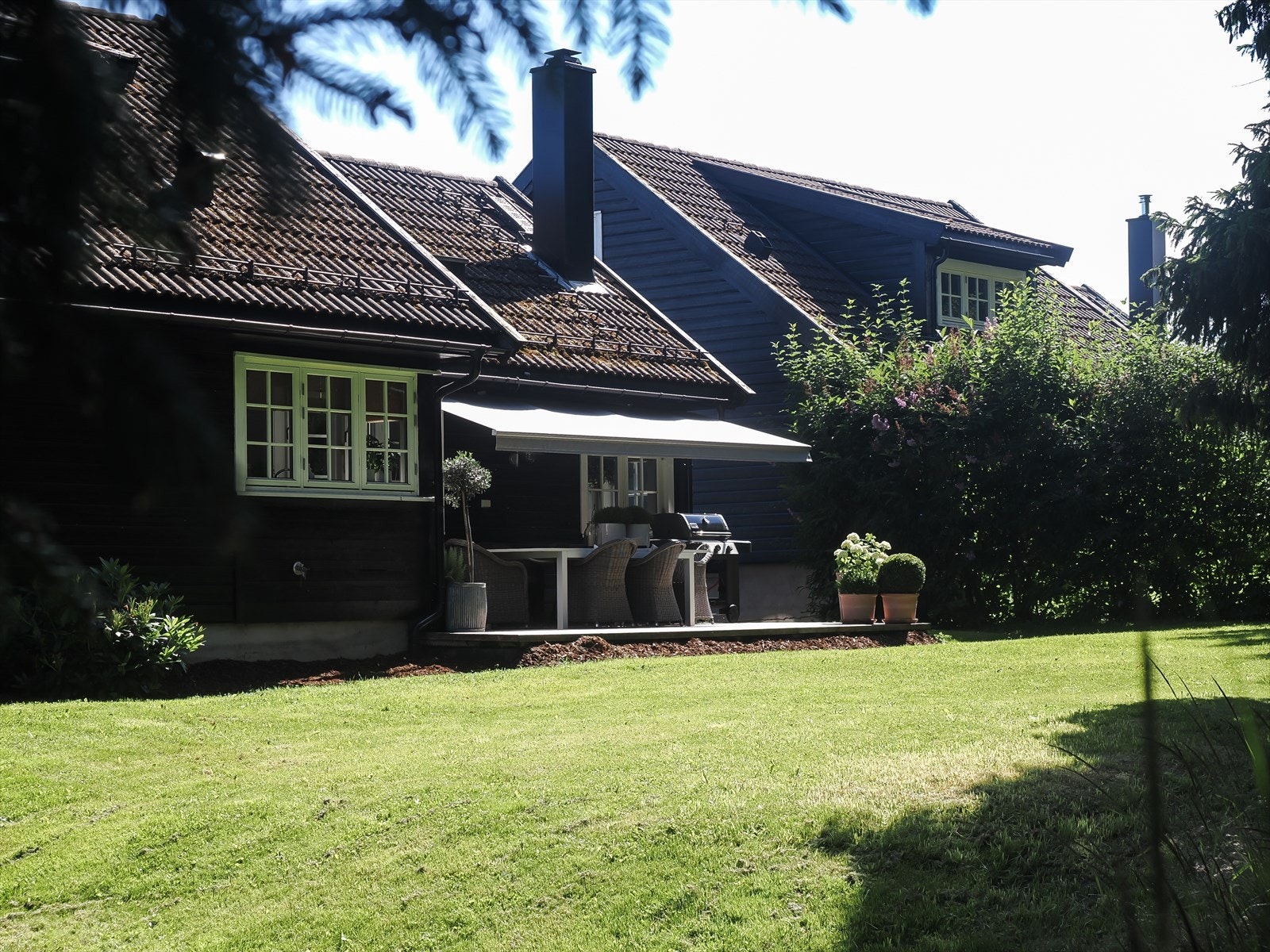 Skjermet og hyggelig hage med plen og platting/terrasse Galleribilde