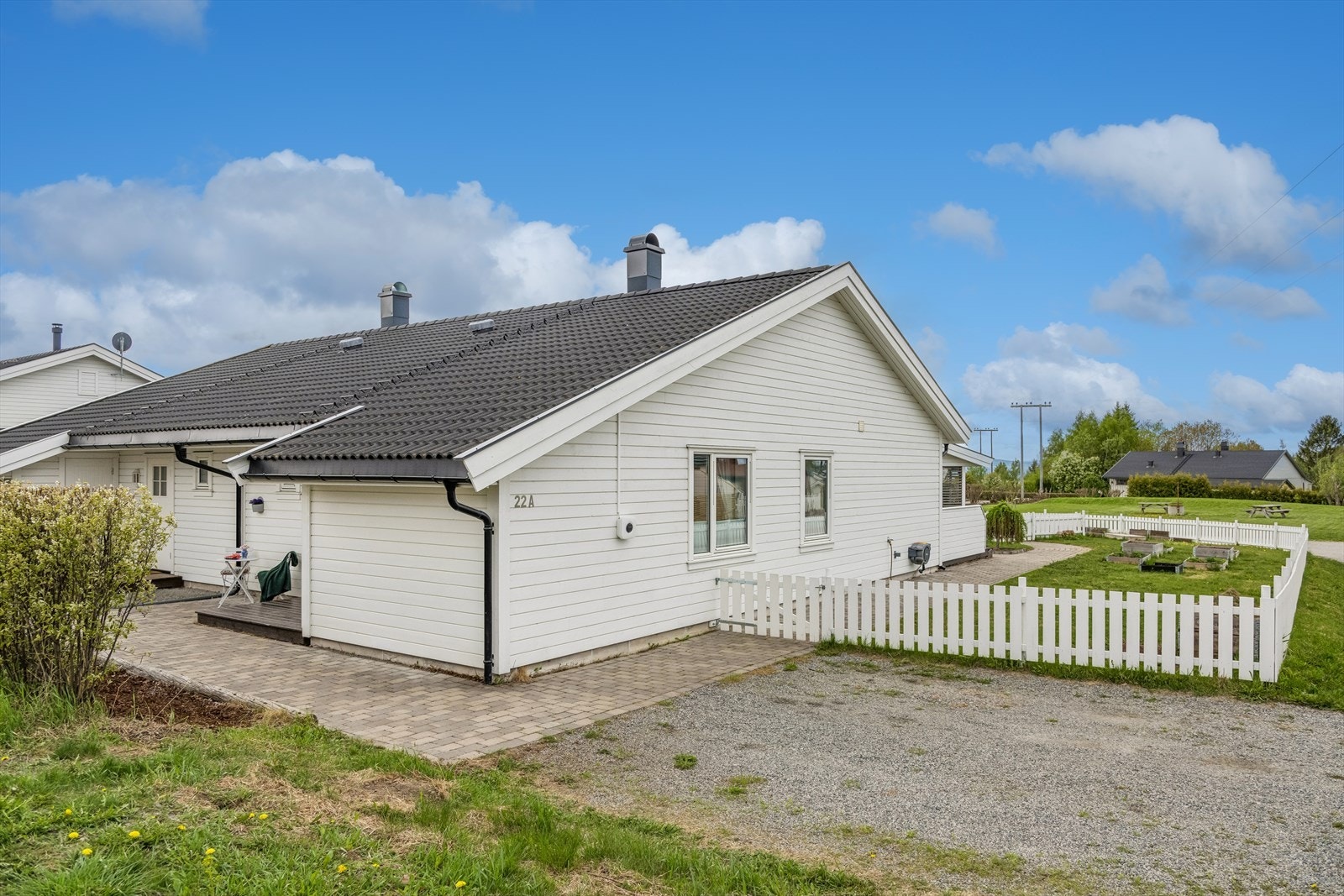 Tomten er opparbeidet med plen, belegningsstein ved inngangspartiet og gruset gårdsplass. Galleribilde