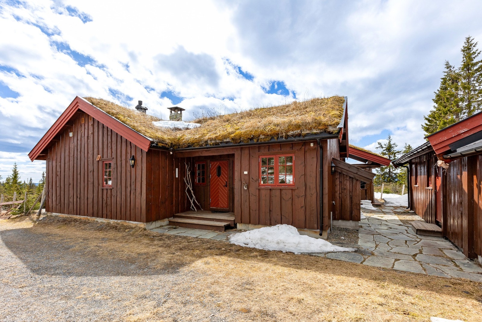 Naturstein og tretrapp leder frem til et takoverbygd inngangsparti som gir hytta et lunt og innbydende preg. Galleribilde