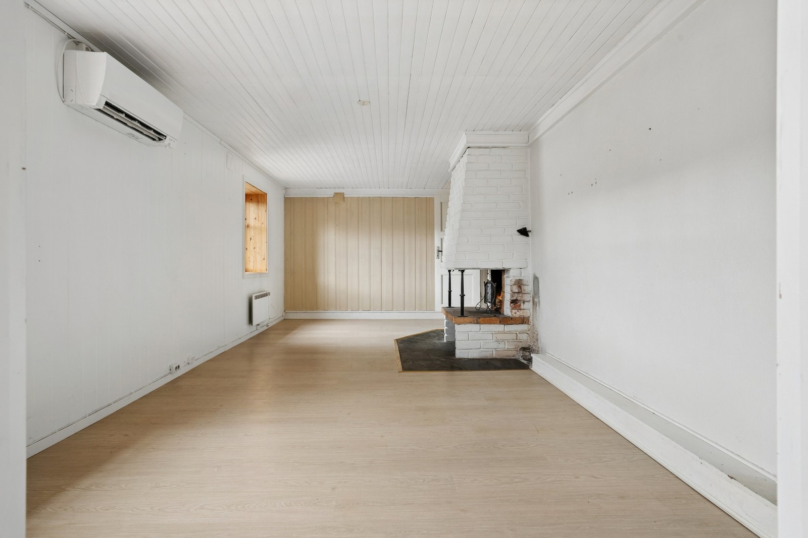 Stuen i kjelleretasjen har en murt peis som et sentralt element i rommet. Galleribilde