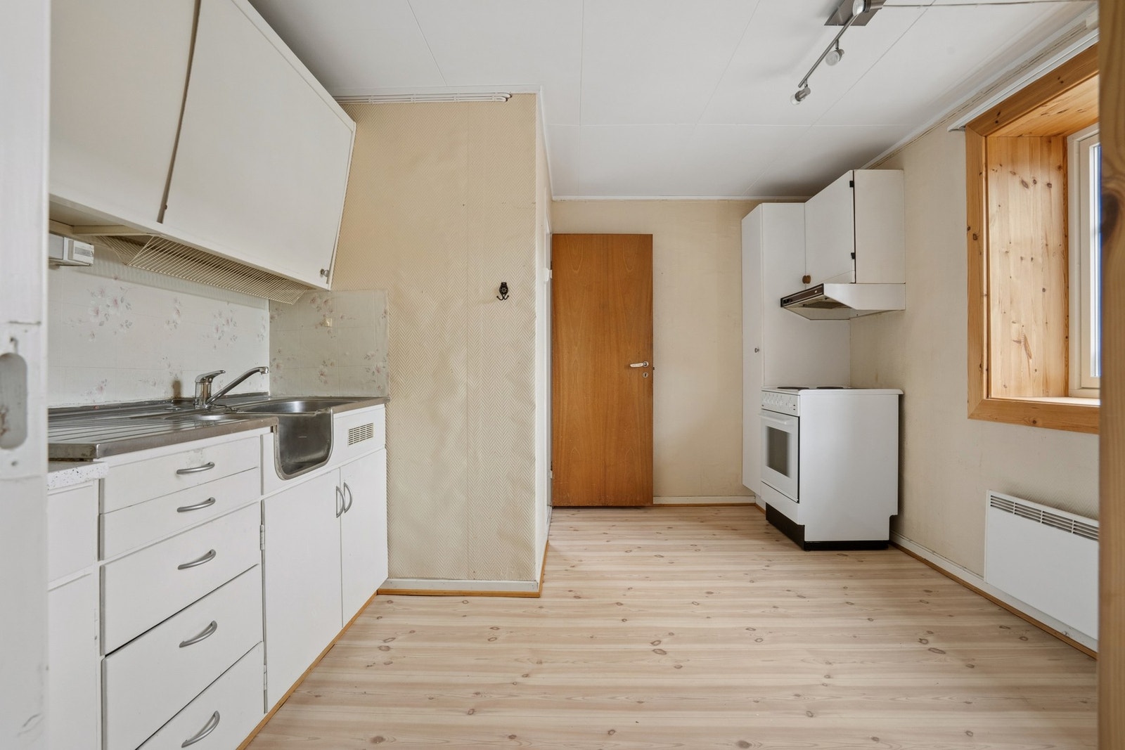 Praktisk kjøkken i kjelleren med benkeplate i laminat og stål. Galleribilde