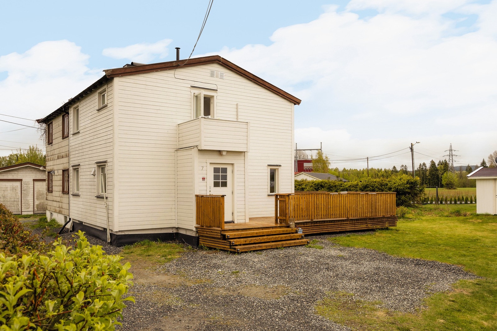 Det er en liten tretrapp opp til inngangspartiet, som er naturlig tilknyttet resten av terrassen og skaper et hyggelig og innbydende uteområde rundt boligen. Galleribilde