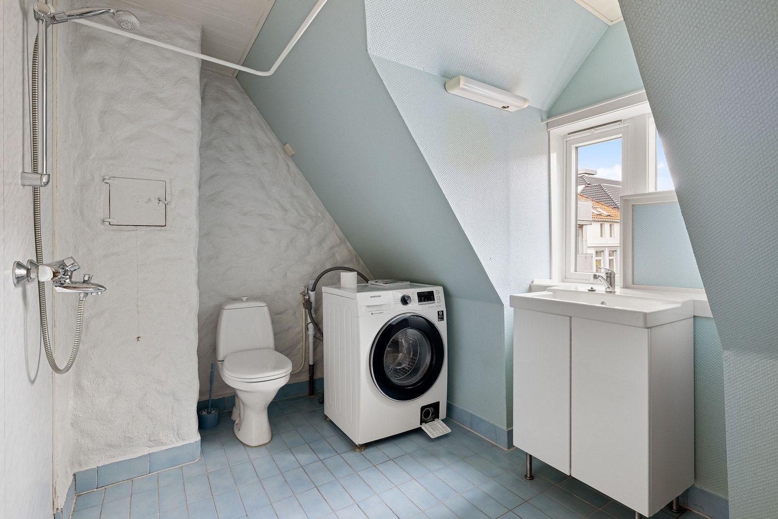 Badet har toalett, dusj, servant med underskap og opplegg for vaskemaskin. Galleribilde