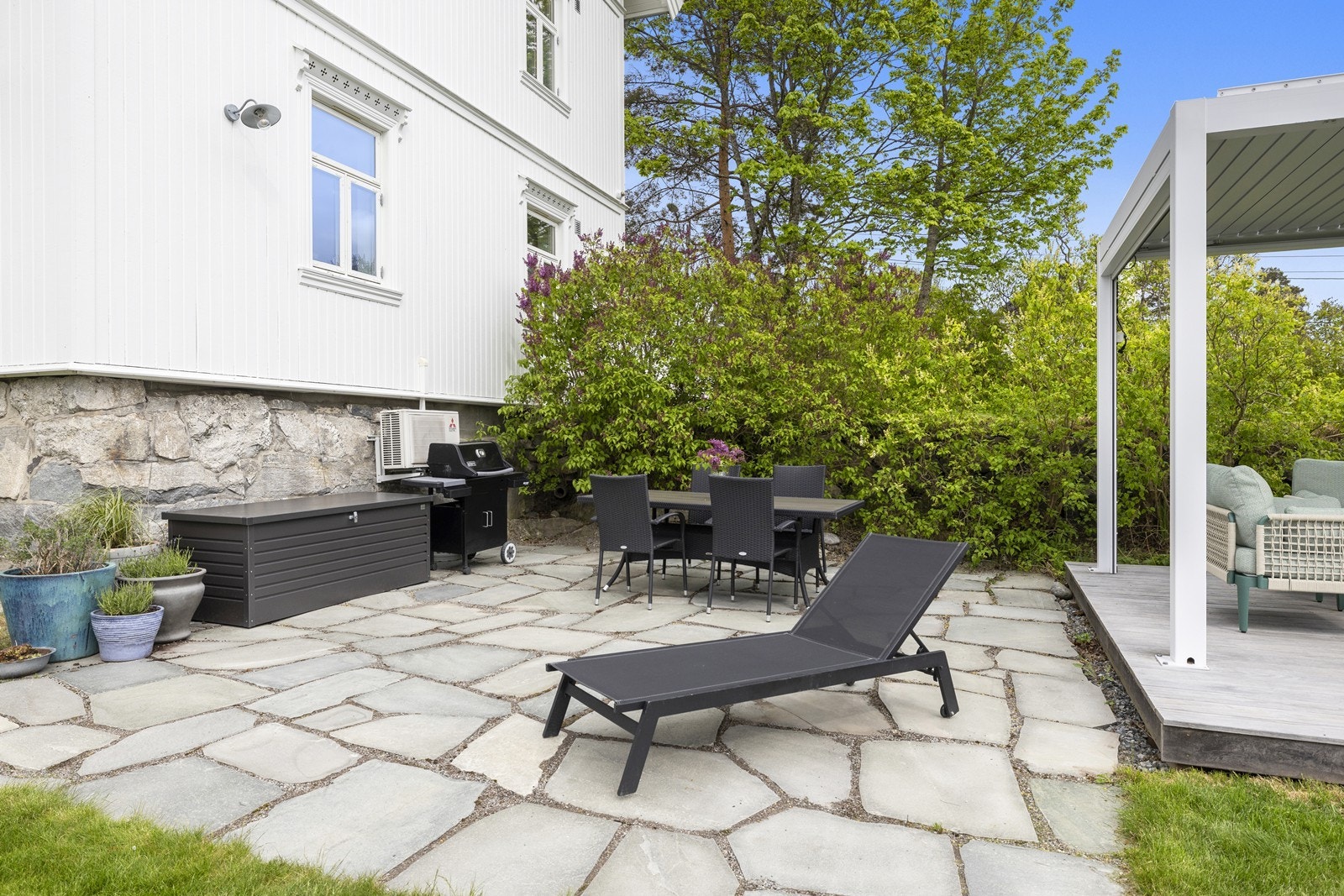 Den steinsatte uteplassen har god plass til grill og spisebord. Galleribilde