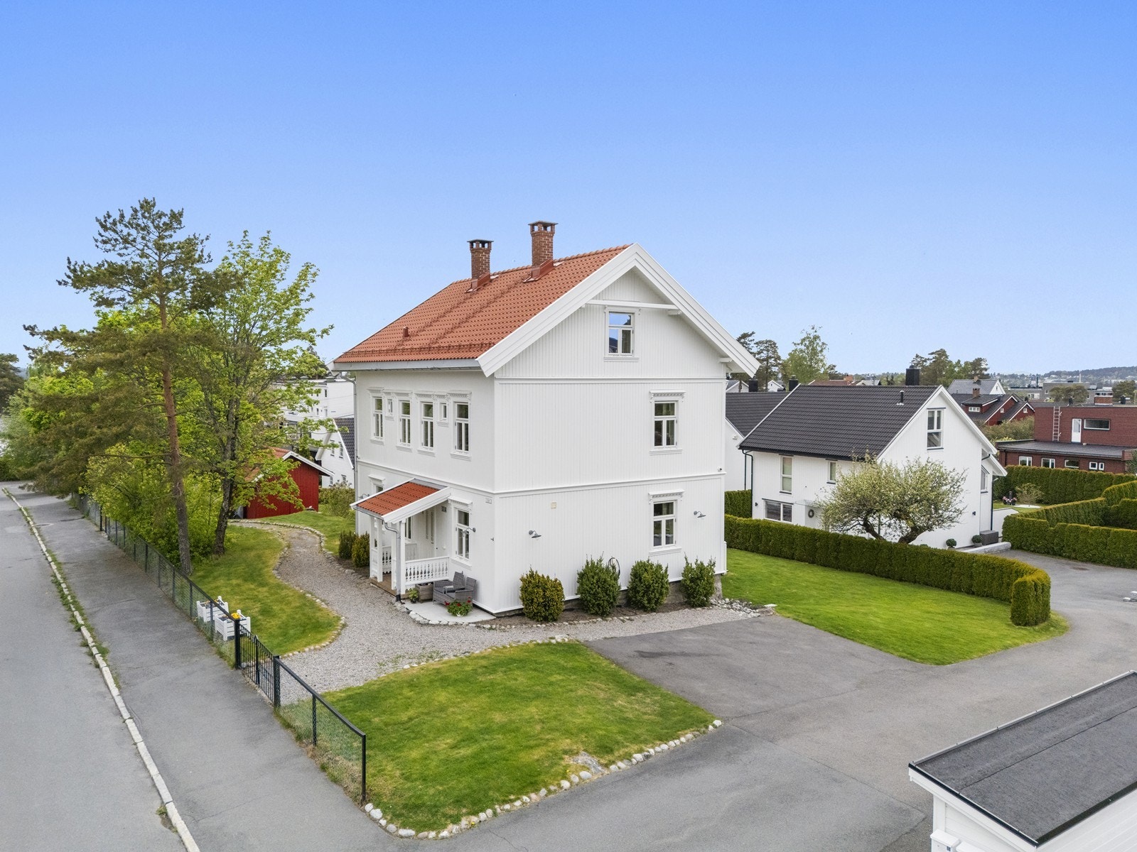Tomten er pent opparbeidet med plen, beplantning og hekk. Galleribilde