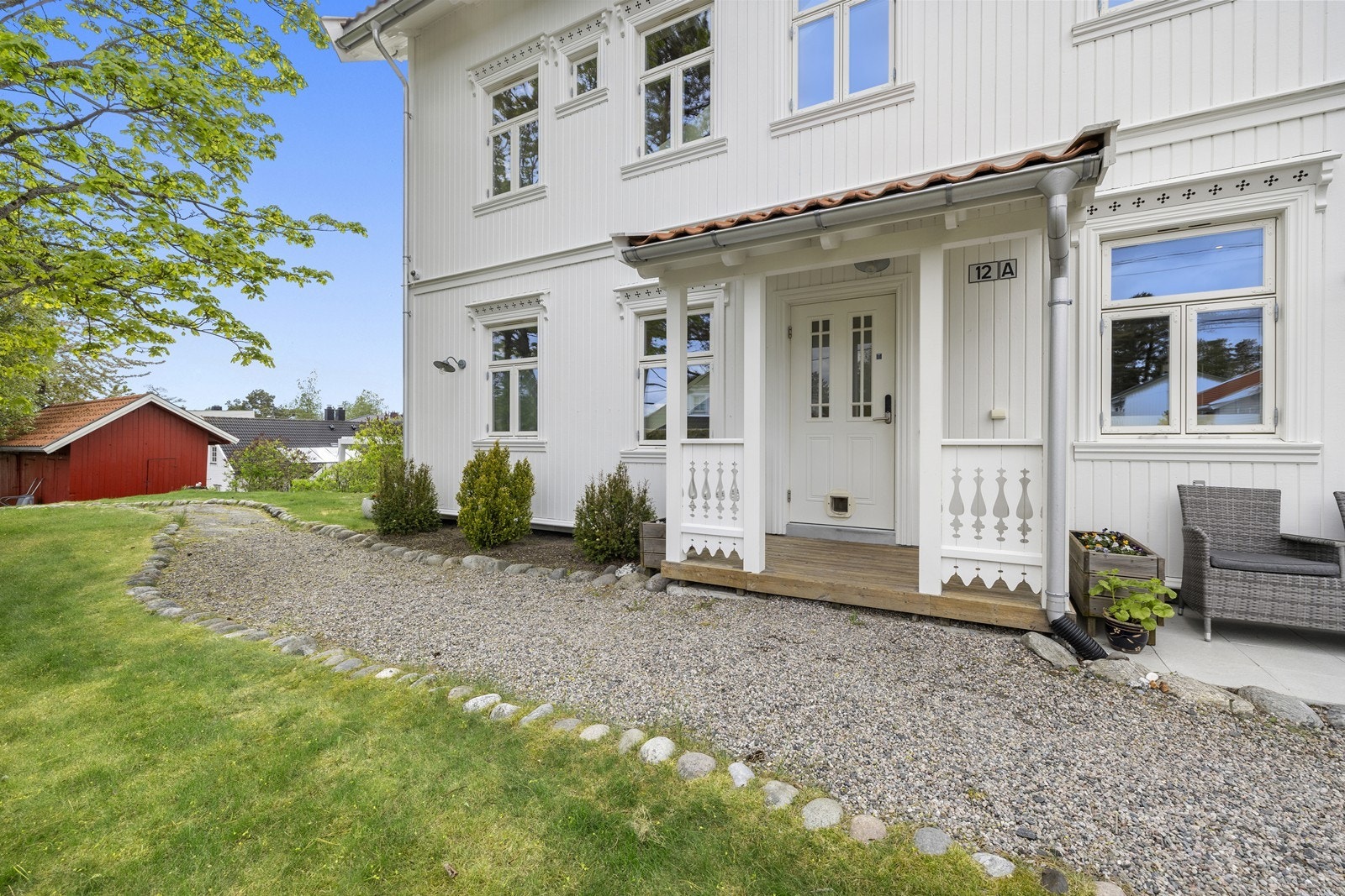 Overbygget inngangsparti og en pen, gruslagt gårdsplass. Galleribilde