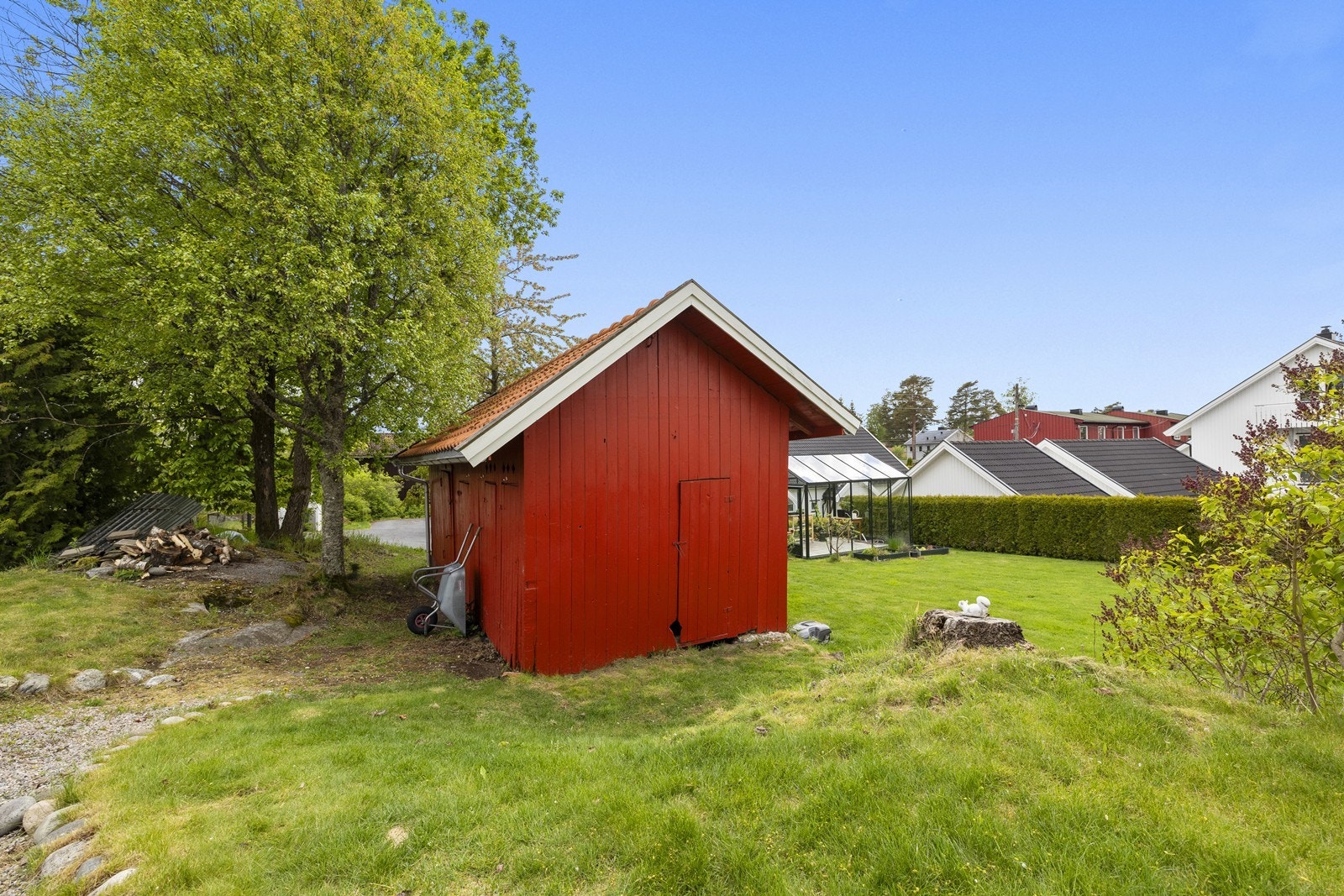 På tomten står også et praktisk uthus for lagring av hageredskaper og ved. Galleribilde