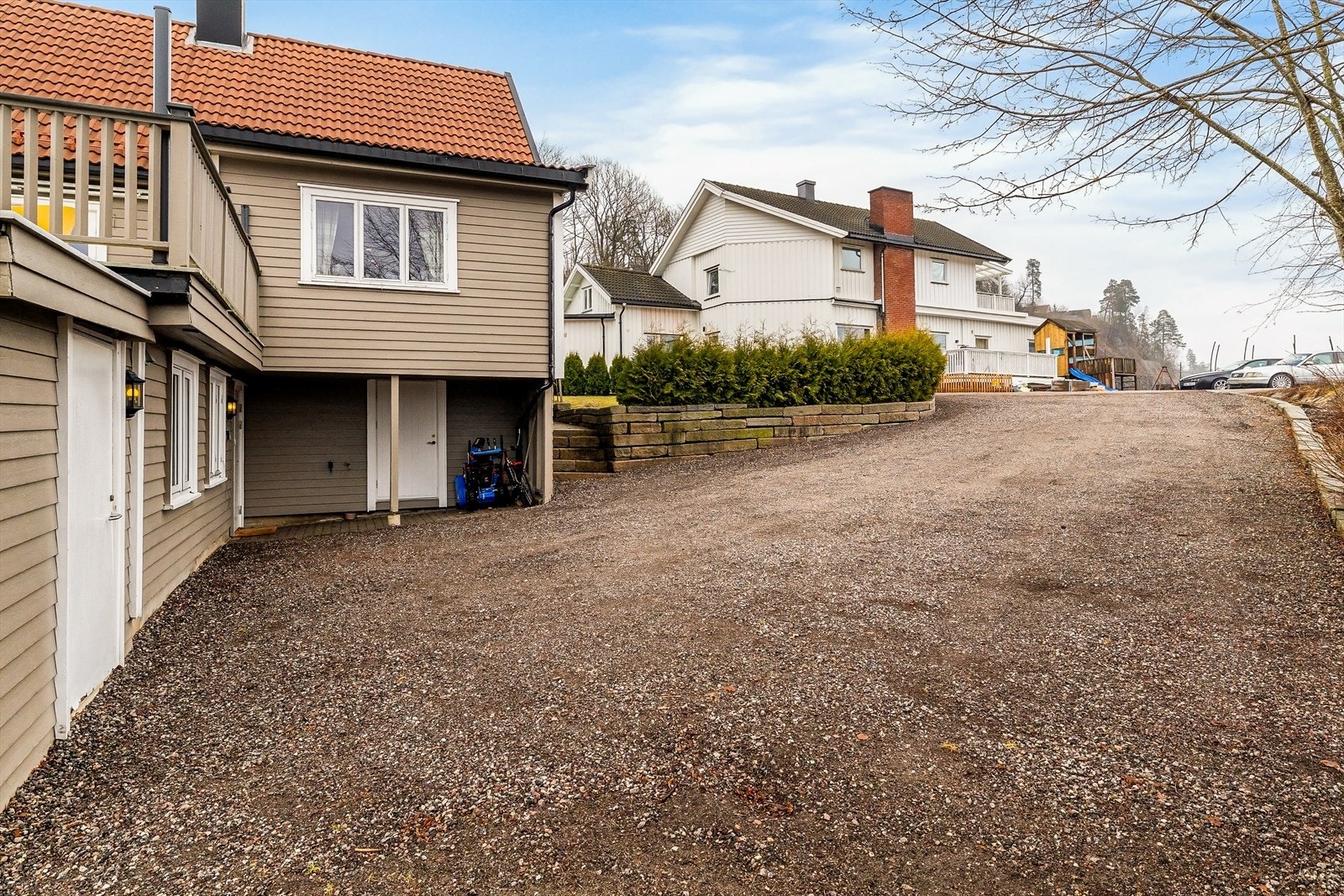 Stor, gruset gårdsplass med god plass til parkering. Galleribilde
