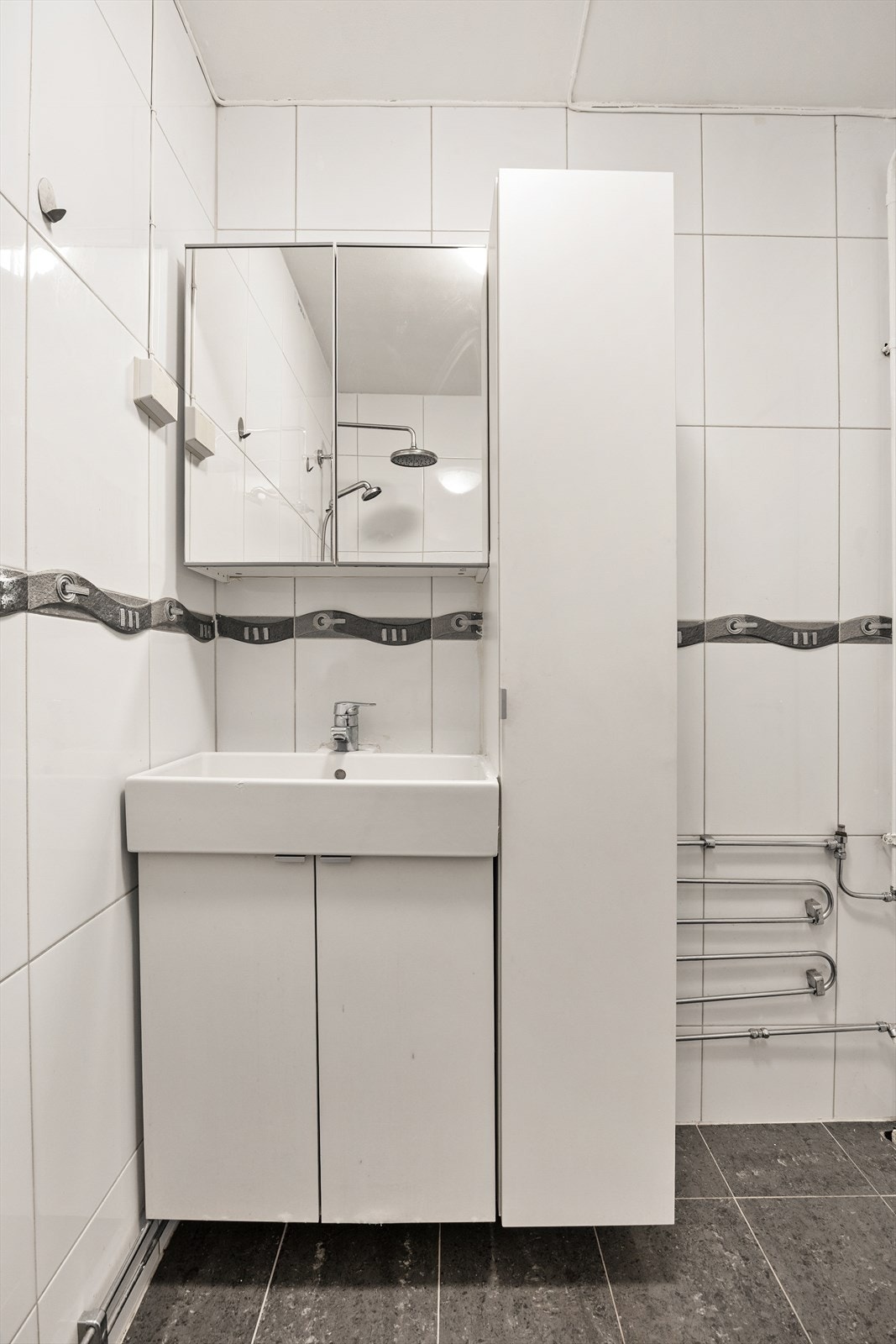 Badet er innredet med servantmøbel og har opplegg for vaskemaskin. Galleribilde