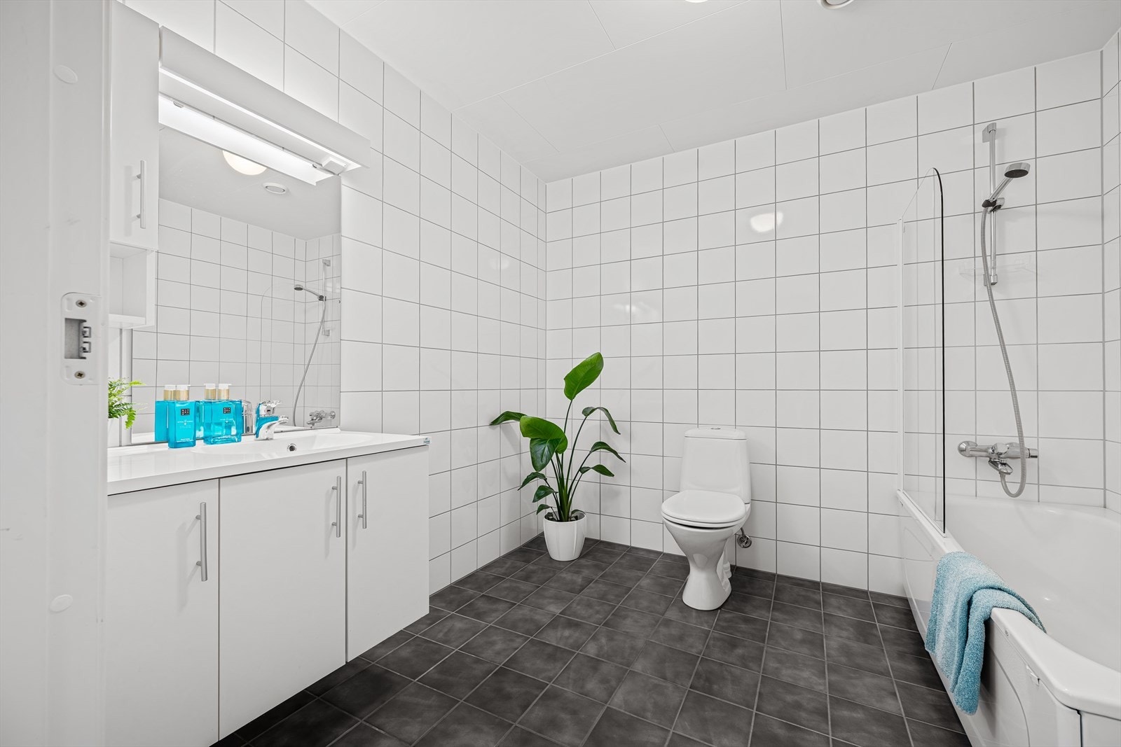 Badet har heldekkende servant på underskap, speil med belysning og balansert ventilasjon. Galleribilde