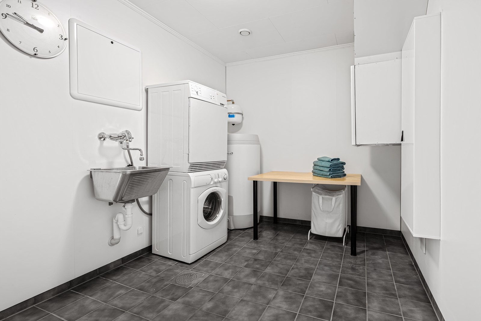 Et separat og praktisk vaskerom med utslagsvask og opplegg for vaskemaskin og tørketrommel. Rommet har elektriske varmekabler i gulvet og balansert ventilasjon. Galleribilde