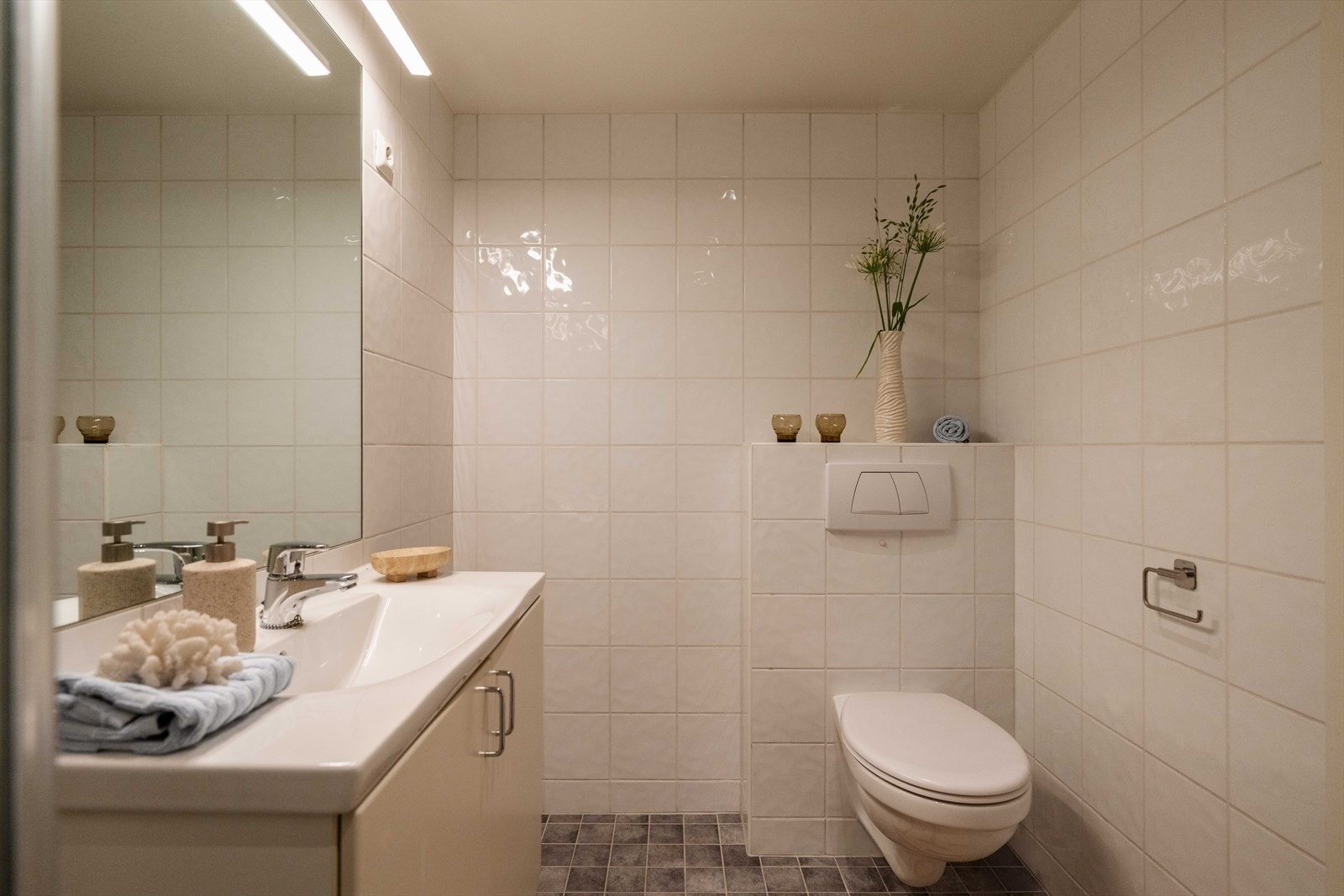 Badet er innredet med vegghengt klosett og servant nedfelt i baderomsinnredning. Galleribilde