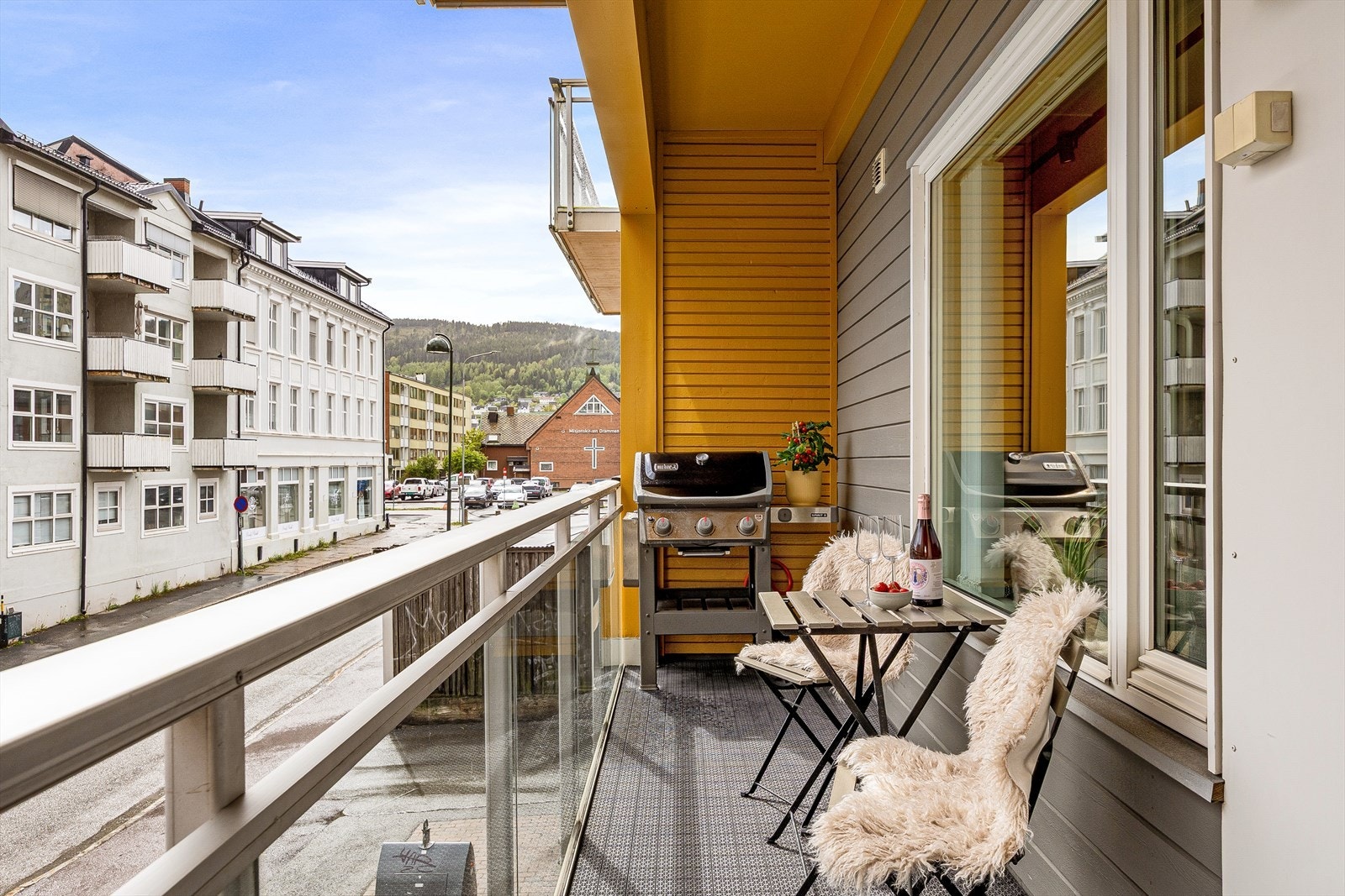 Leiligheten har en takoverbygget veranda med plass for cafémøblement Galleribilde