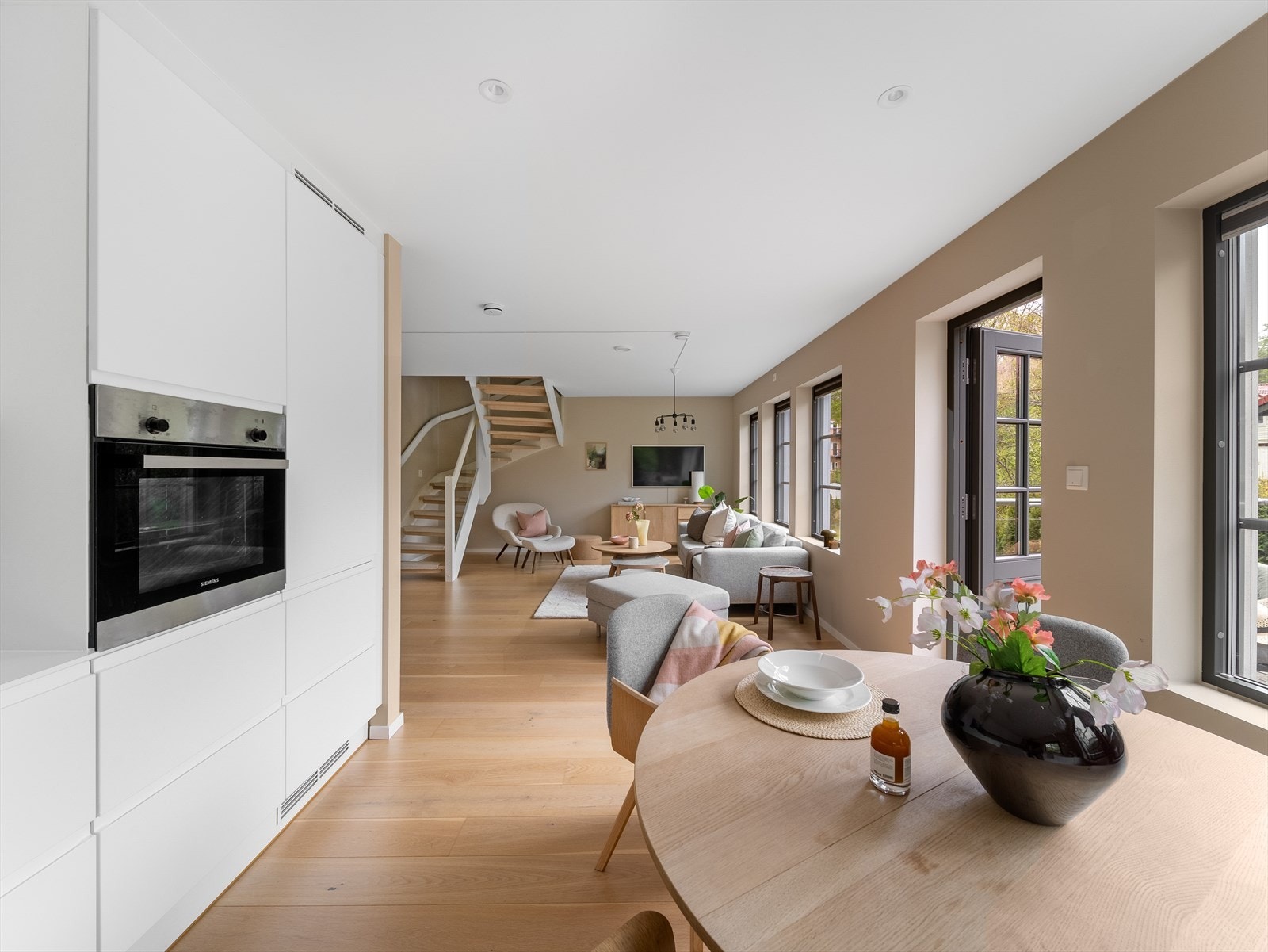 Innredningen er fra JKE og har hvite, slette fronter med integrerte håndtak og takhøye skap som gir et elegant og eksklusivt uttrykk. Galleribilde